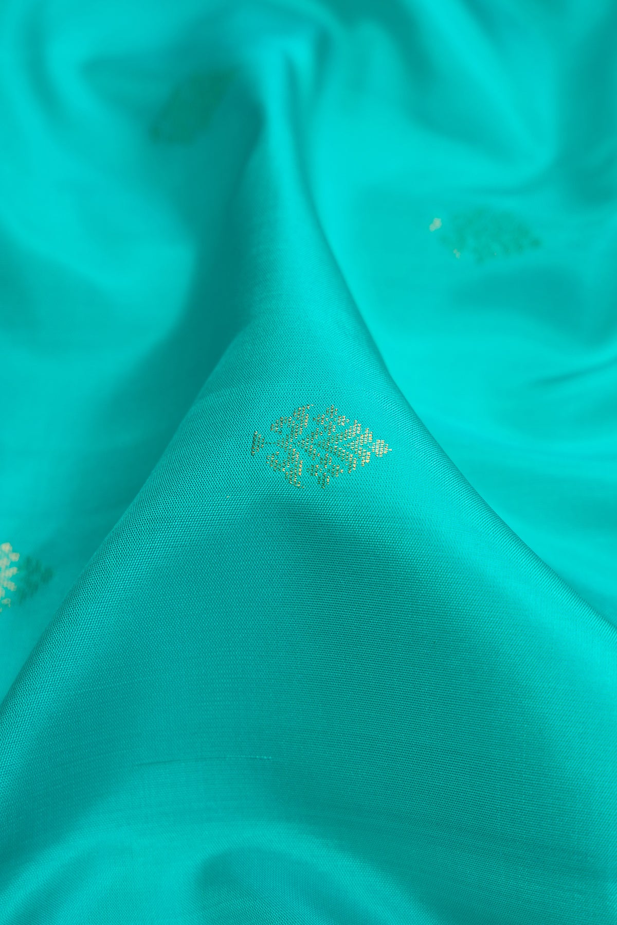Close up of Sky Blue Dual Tone Soft Silk Saree with Zari Butta on the body and Zari Border.  displaying folds