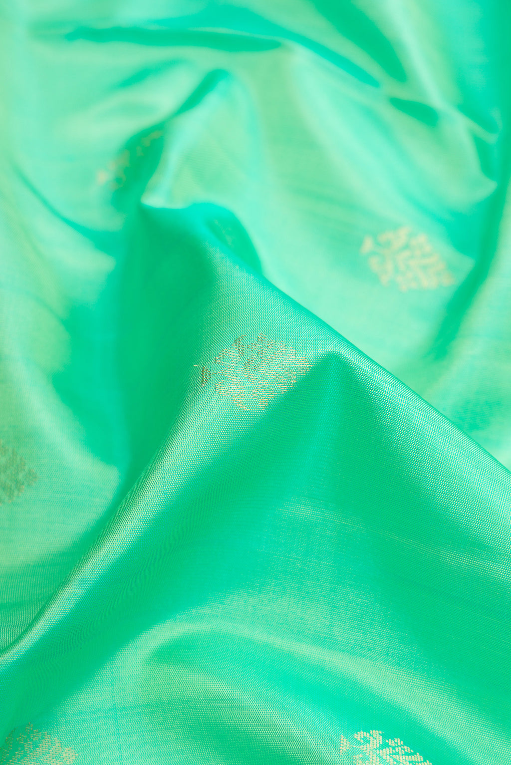 Close up of Pista Green Dual Tone Soft Silk Saree with Zari Butta on the body and Zari Border.  displaying folds