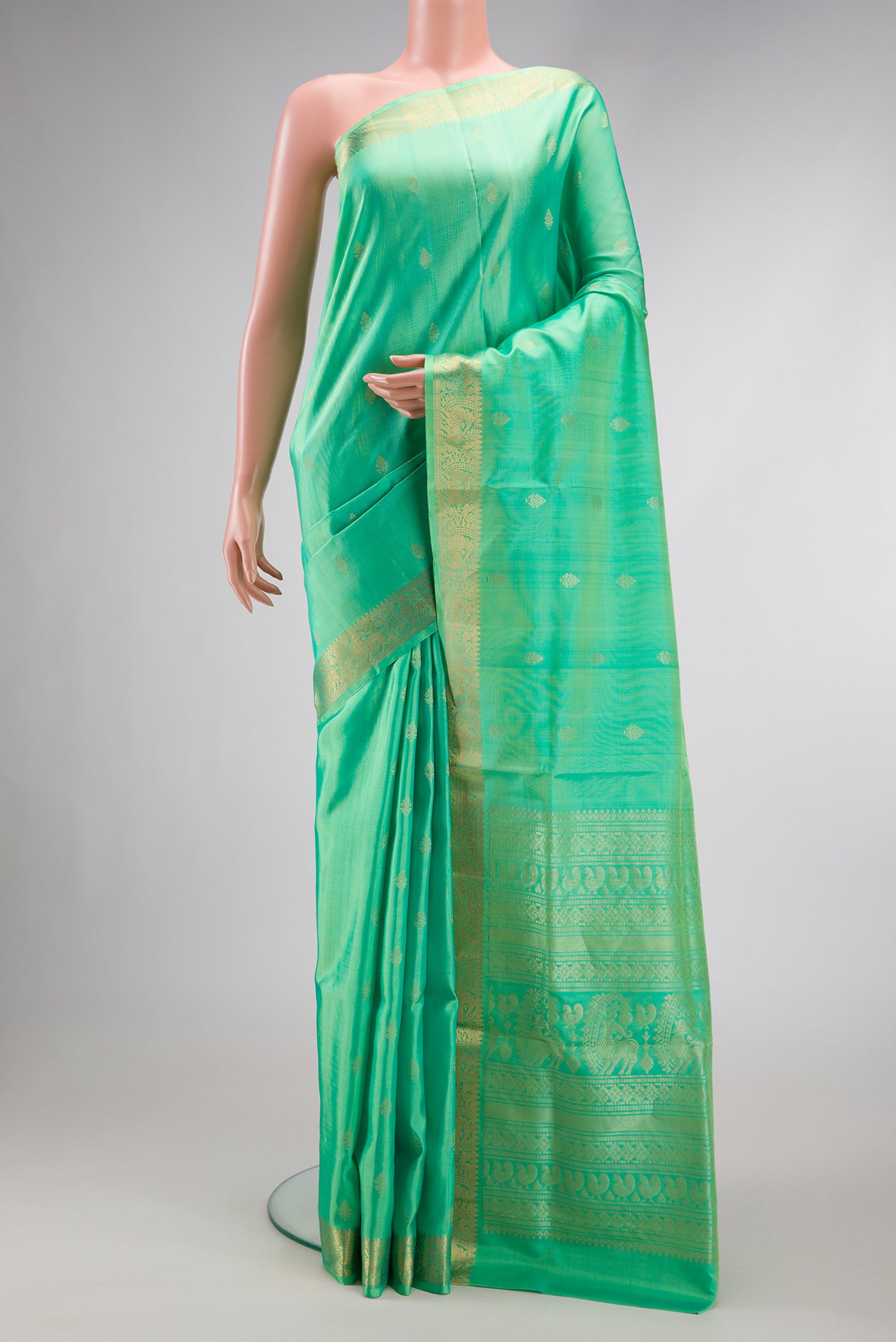 Pista Green Dual Tone Soft Silk Saree with Zari Butta on the body and Zari Border.  displayed on a mannequin