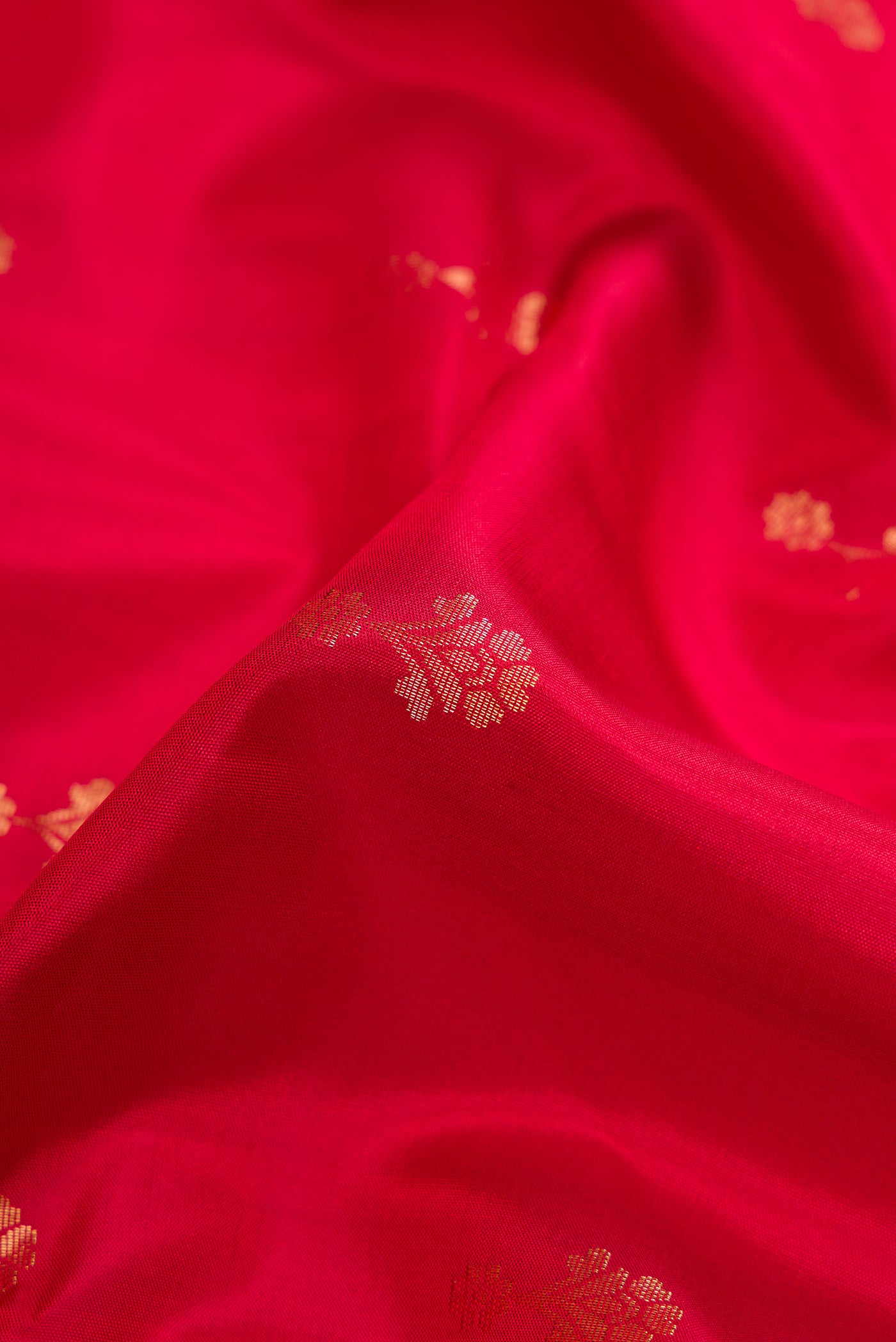 Close up of Red Dual Tone Soft Silk Saree with Zari Butta on the body and Zari Border.  displaying folds