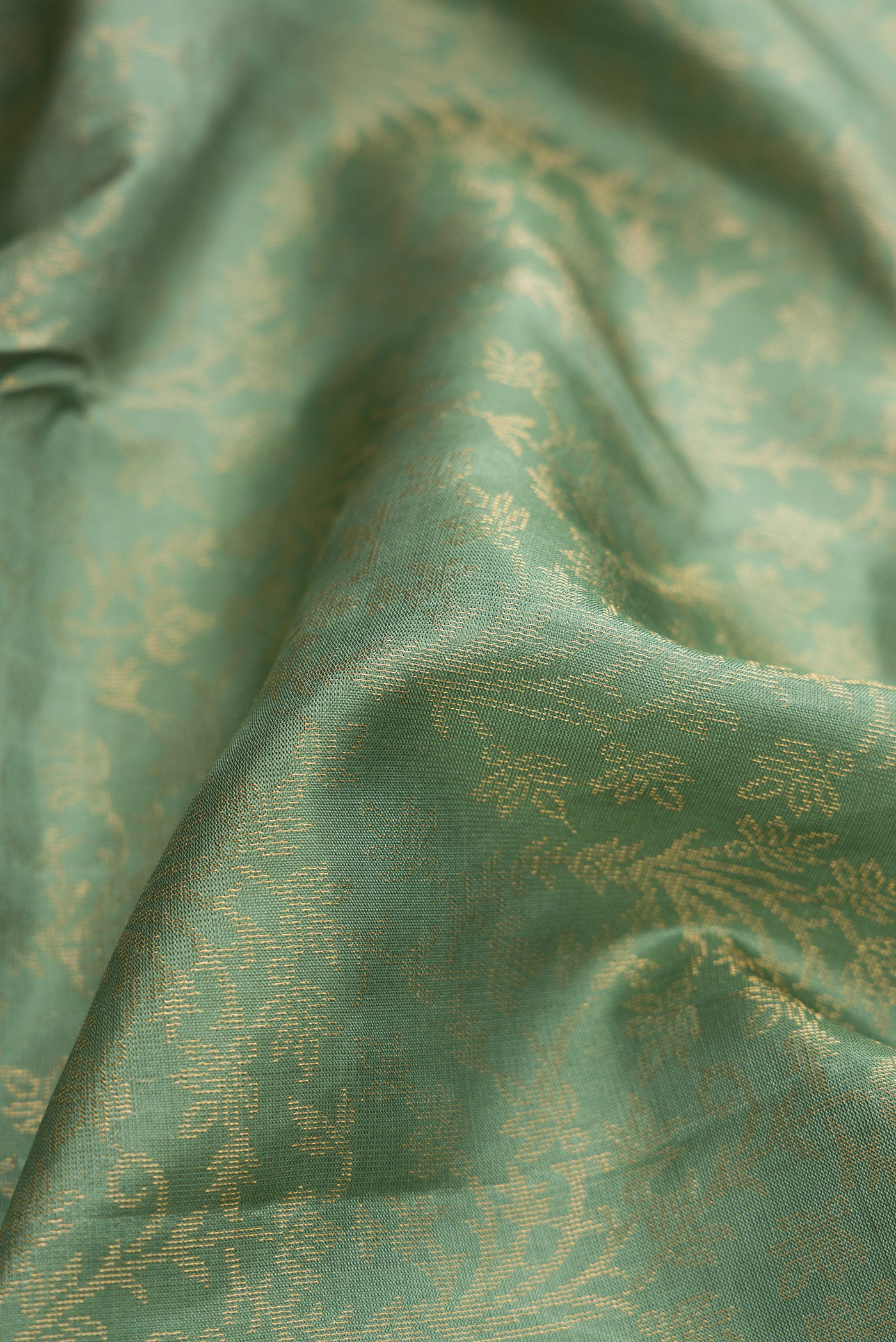 Close up of Light Green Dual Tone Soft Silk Saree with Zari Brocade on the body and Zari Border.  displaying folds