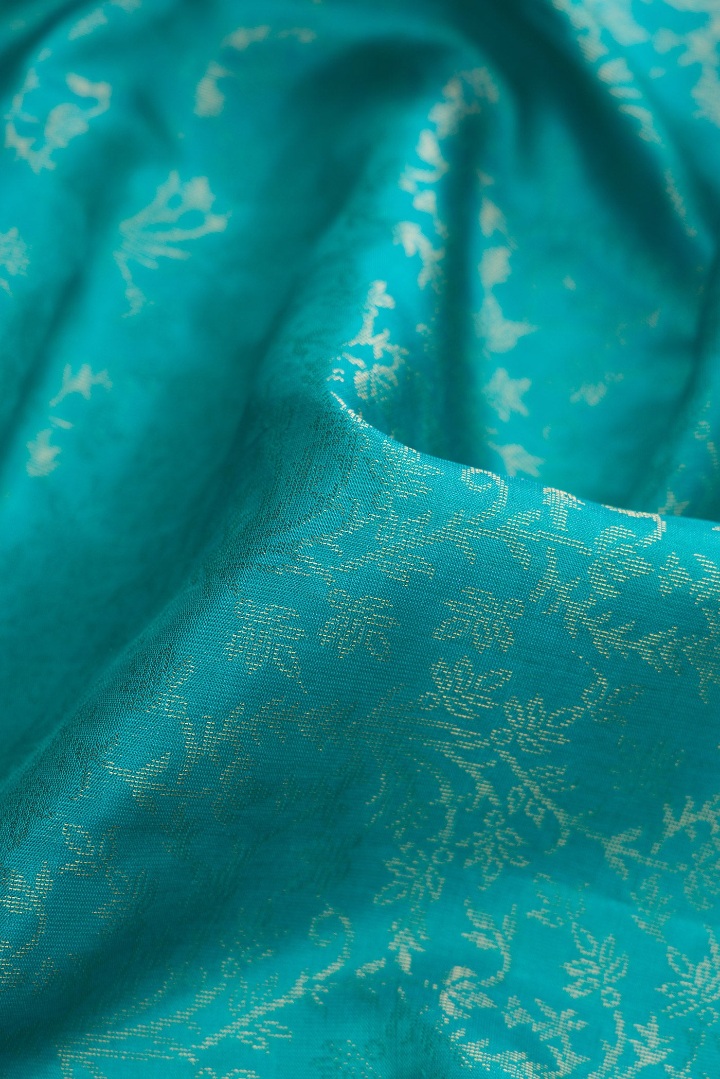 Close up of Sky Blue Dual Tone Soft Silk Saree with Zari Brocade on the body and Zari Border.  displaying folds