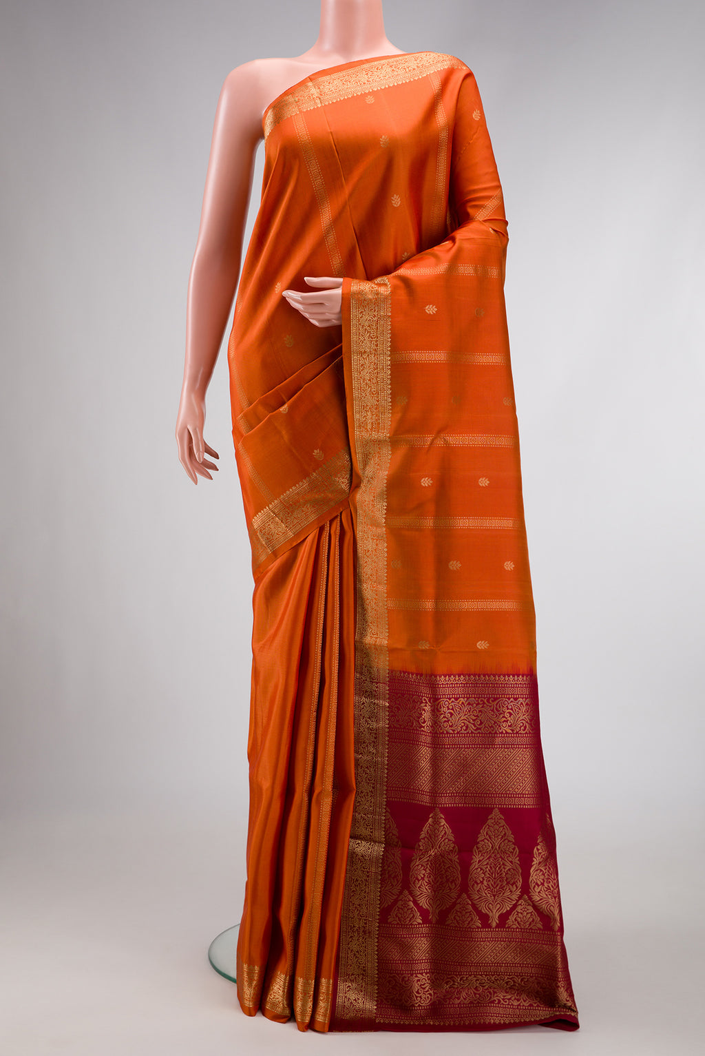 Brick Orange Dual Tone Soft Silk Saree with Stripes on the body and Zari Border.  displayed on a mannequin