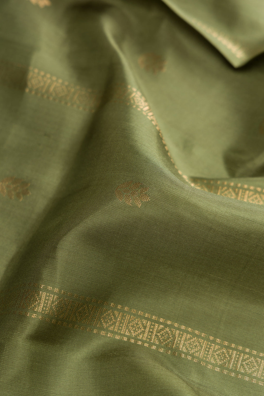 Close up of Mehandi Green Dual Tone Soft Silk Saree with Zari Butta on the body and Zari Border.  displaying folds