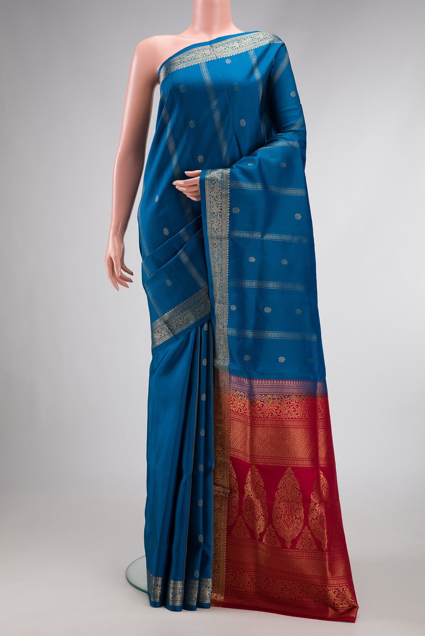 Peacock Blue Dual Tone Soft Silk Saree with Zari Butta on the body and Zari Border.  displayed on a mannequin