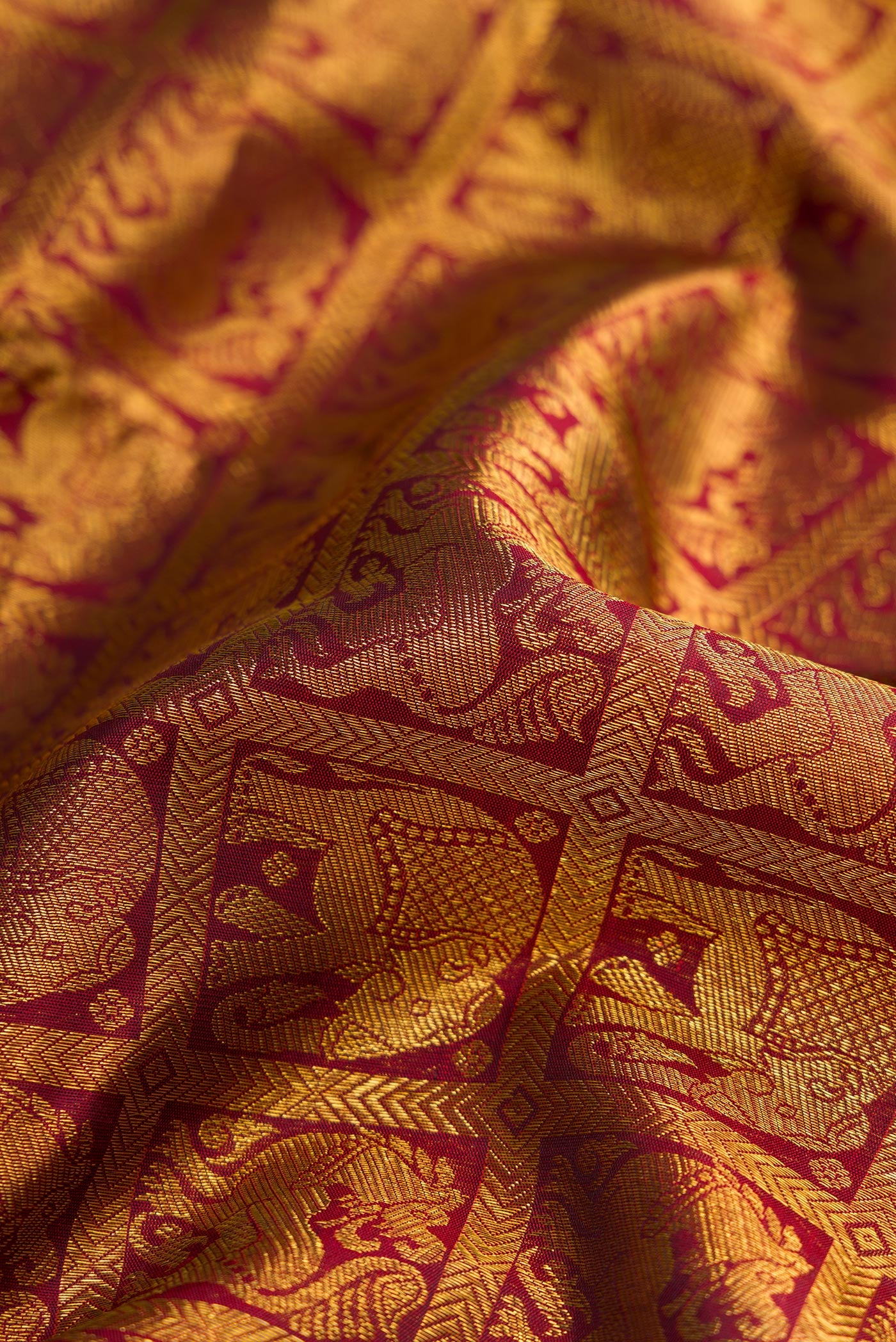 Close up of Maroon Dual Tone Kanchipuram Silk Saree with Zari Brocade on the body and Zari Border.  displaying folds