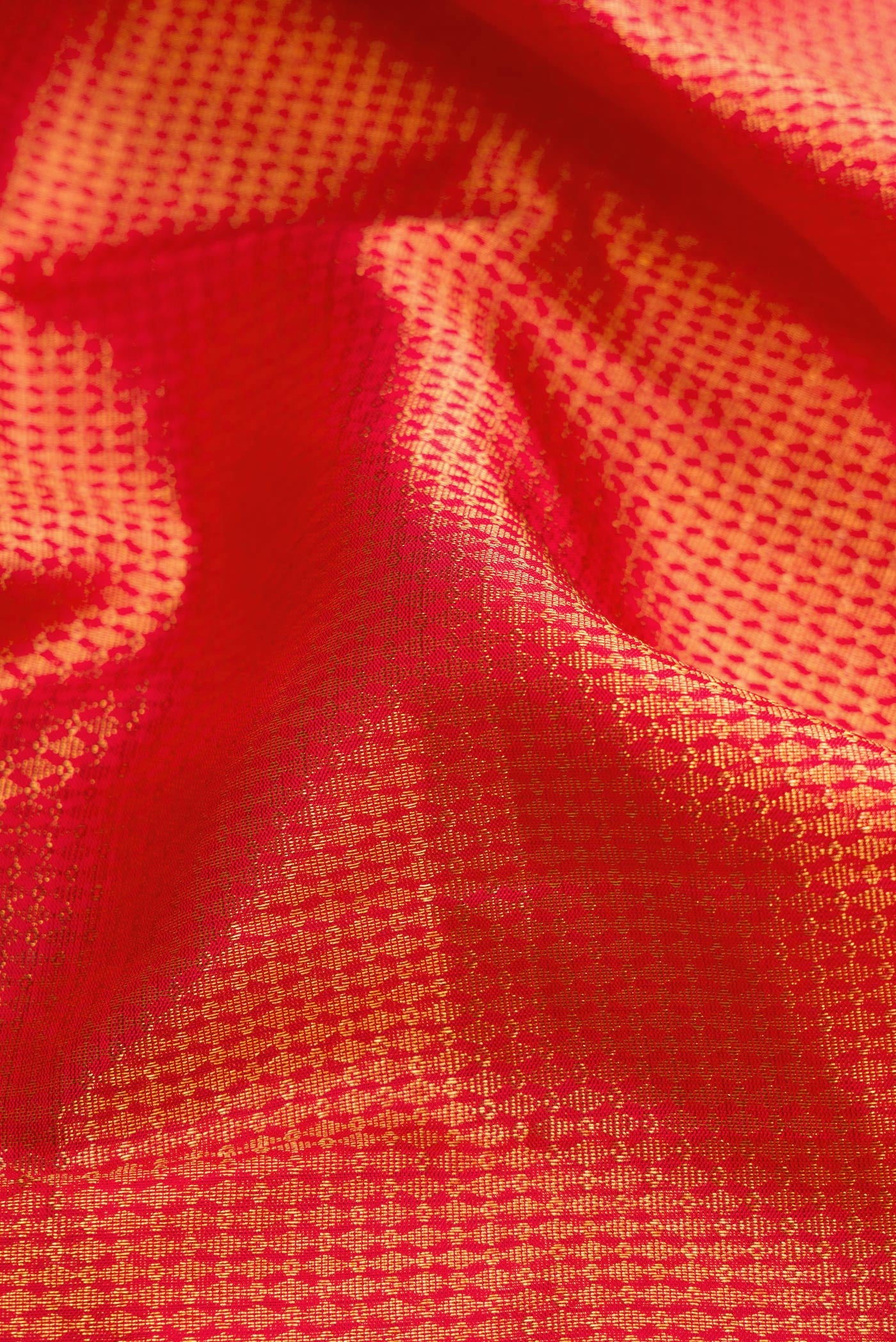 Close up of Red Dual Tone Kanchipuram Silk Saree with Zari Brocade on the body and Zari Border.  displaying folds