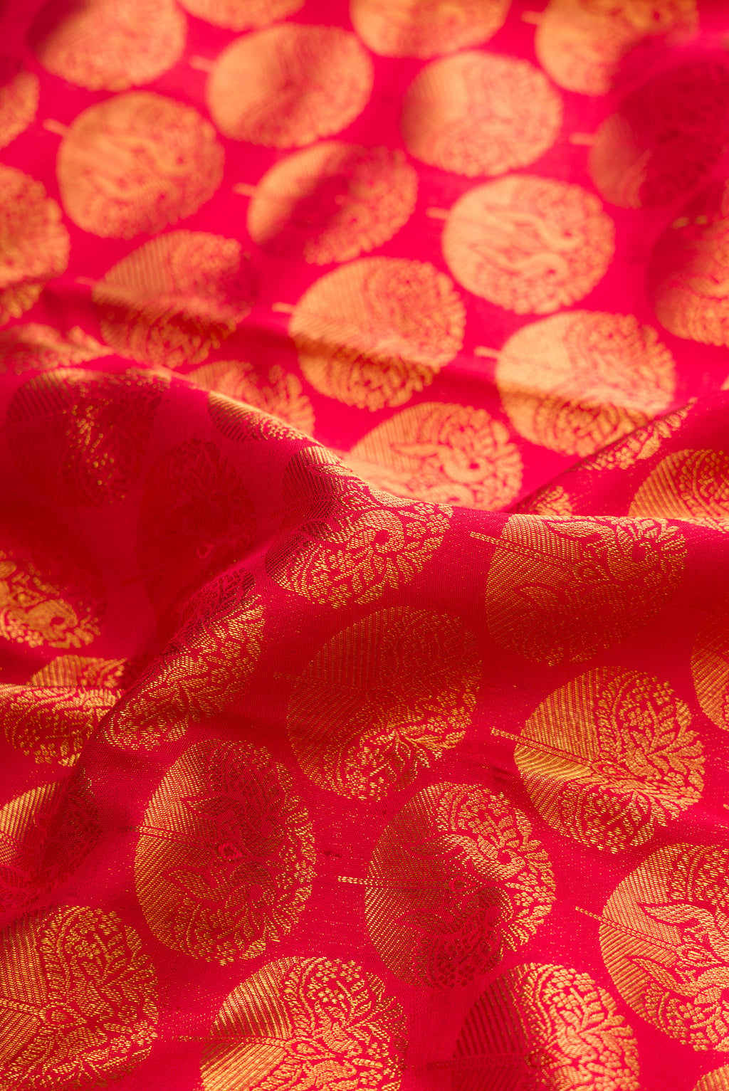 Close up of Red Dual Tone Kanchipuram Silk Saree with Zari Brocade on the body and Zari Border.  displaying folds