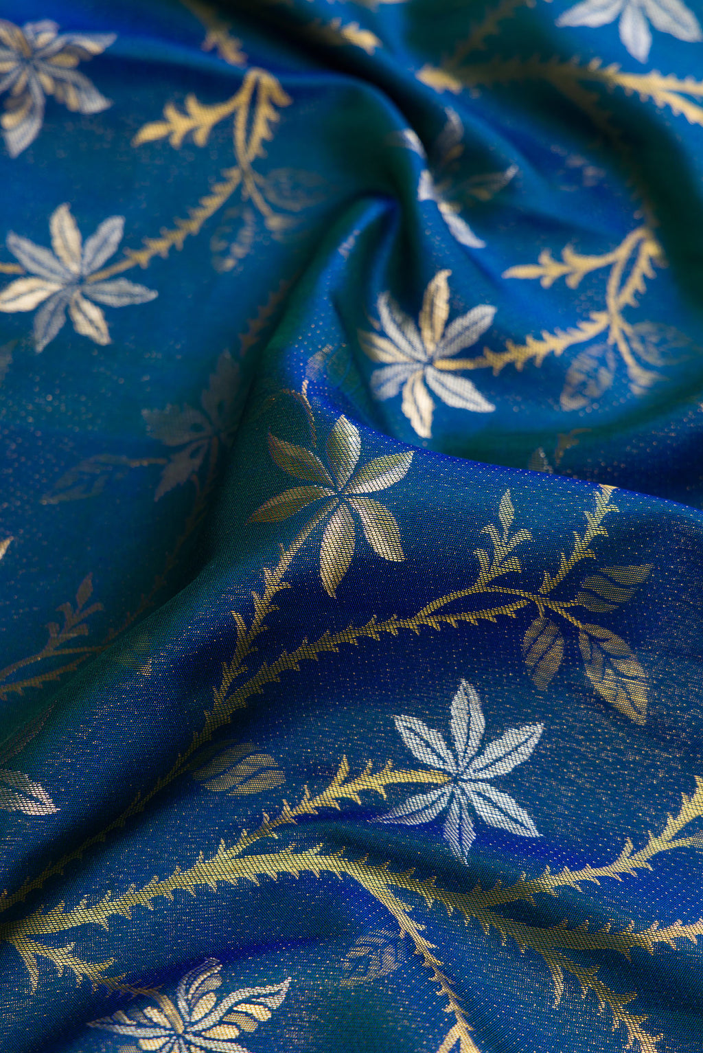 Close up of Peacock Blue Dual Tone Kanchipuram Silk Saree with Zari Brocade on the body and Fancy Border.  displaying folds