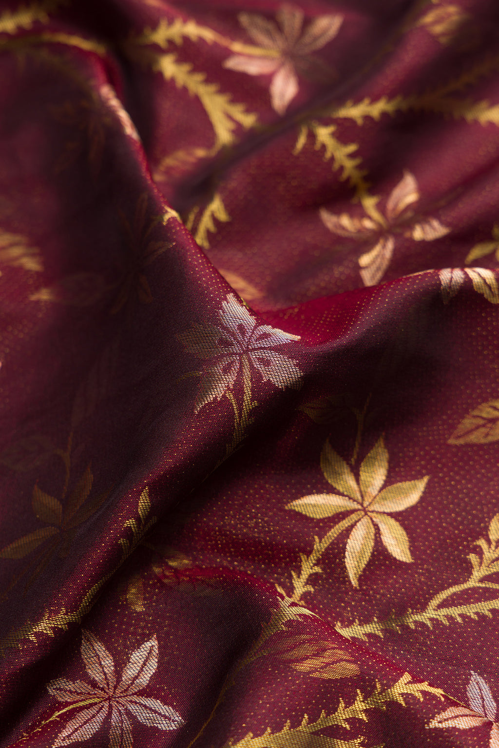 Close up of Maroon Dual Tone Kanchipuram Silk Saree with Zari Brocade on the body and Fancy Border.  displaying folds