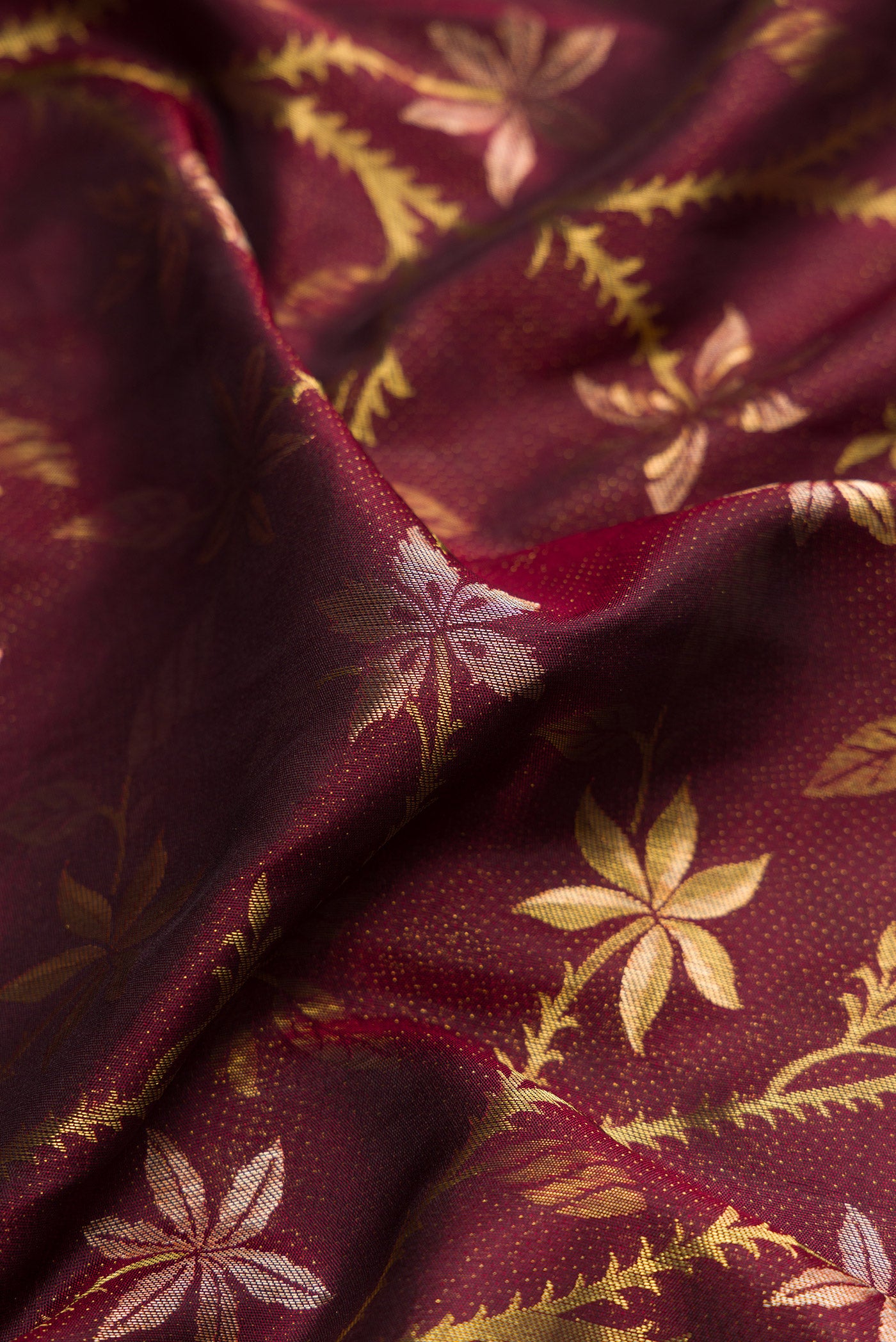 Close up of Maroon Dual Tone Kanchipuram Silk Saree with Zari Brocade on the body and Fancy Border.  displaying folds
