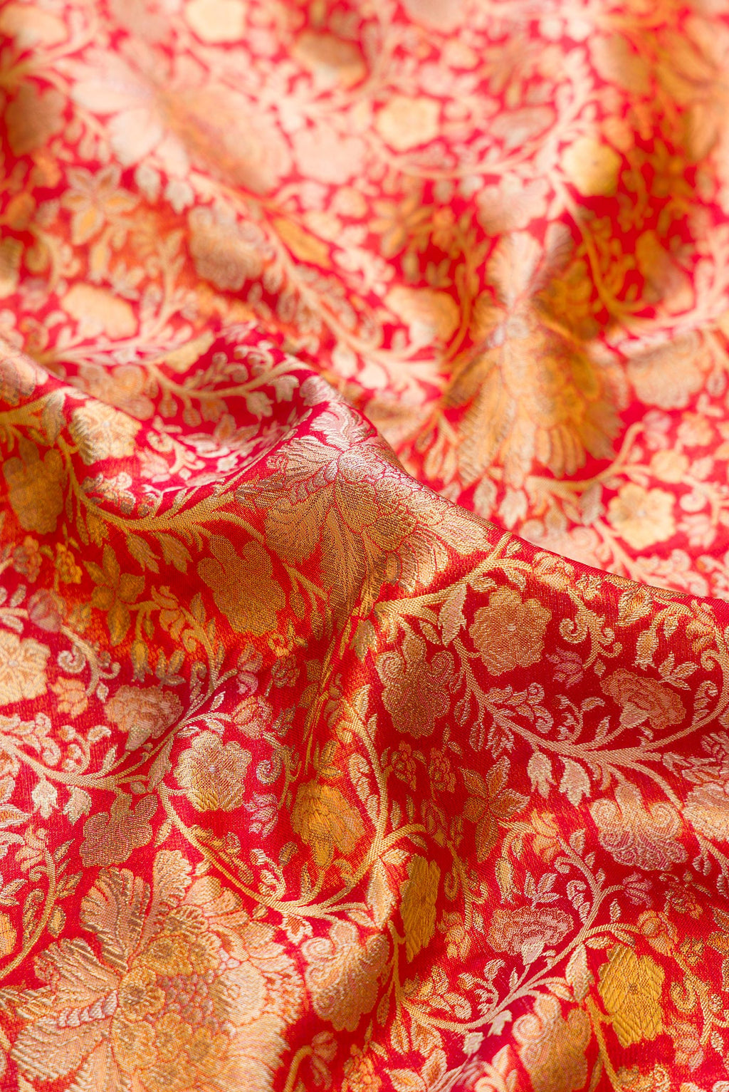 Close up of Red Dual Tone Kanjivaram Tissue Silk Saree with Zari Brocade on the body and Zari Border.  displaying folds