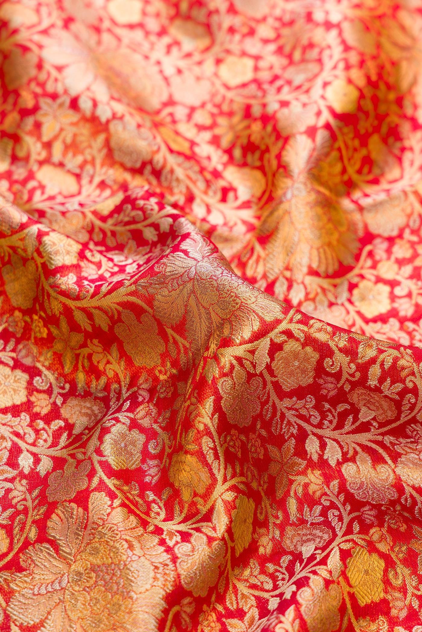 Close up of Red Dual Tone Kanjivaram Tissue Silk Saree with Zari Brocade on the body and Zari Border.  displaying folds