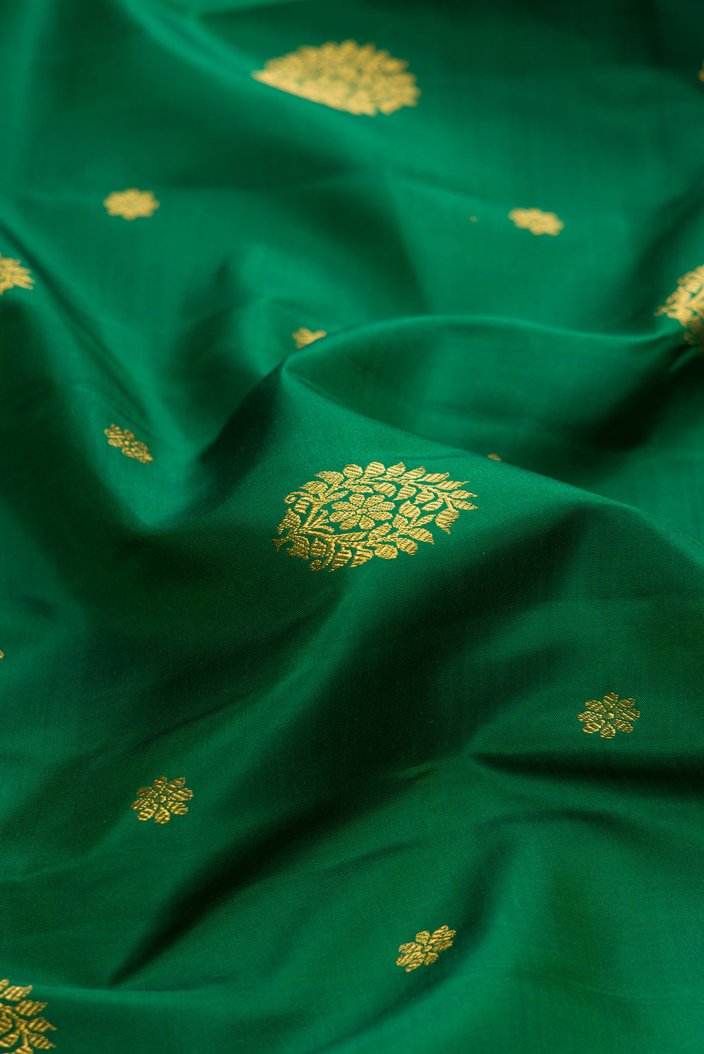 Close up of Bottle Green Kanjivaram Silk Saree with Zari Butta on the body and Zari Border.  displaying folds