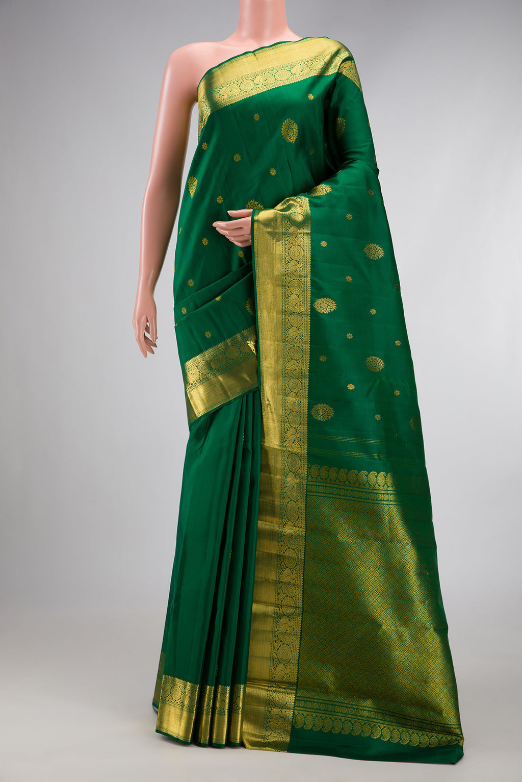 Bottle Green Kanjivaram Silk Saree with Zari Butta on the body and Zari Border.  displayed on a mannequin