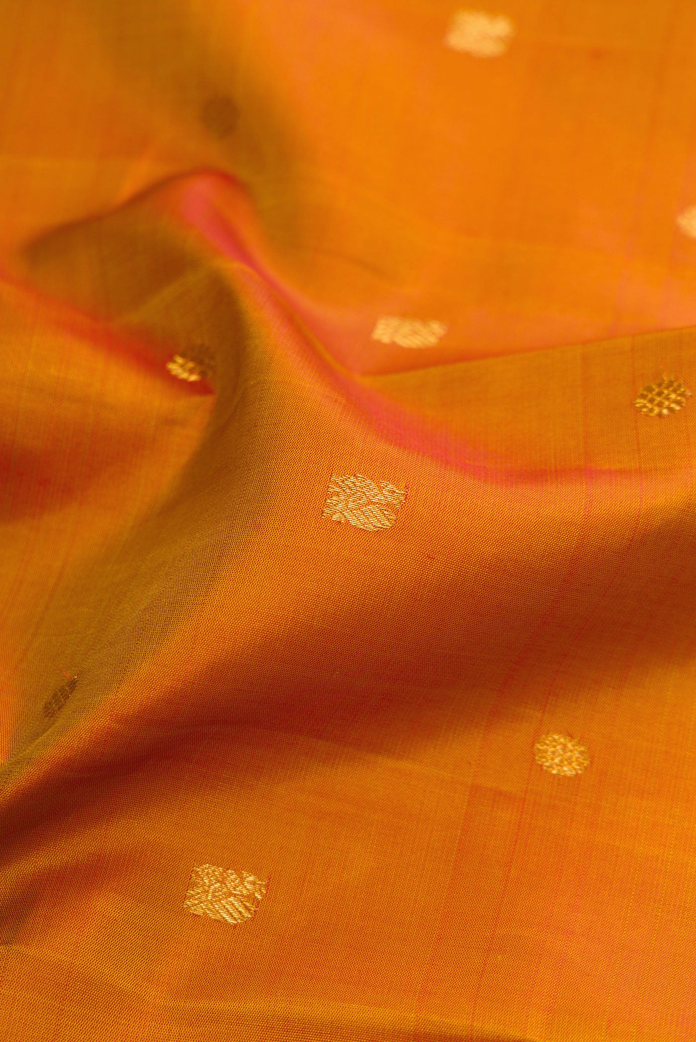 Close up of Mustard Kanjivaram Silk Saree with Zari Butta on the body and Zari Border.  displaying folds