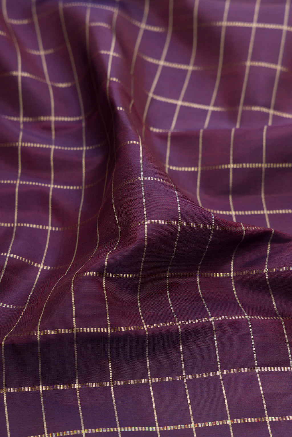 Close up of Purple Kanchipuram Silk Saree with Checked design on the body and Plain Border.  displaying folds