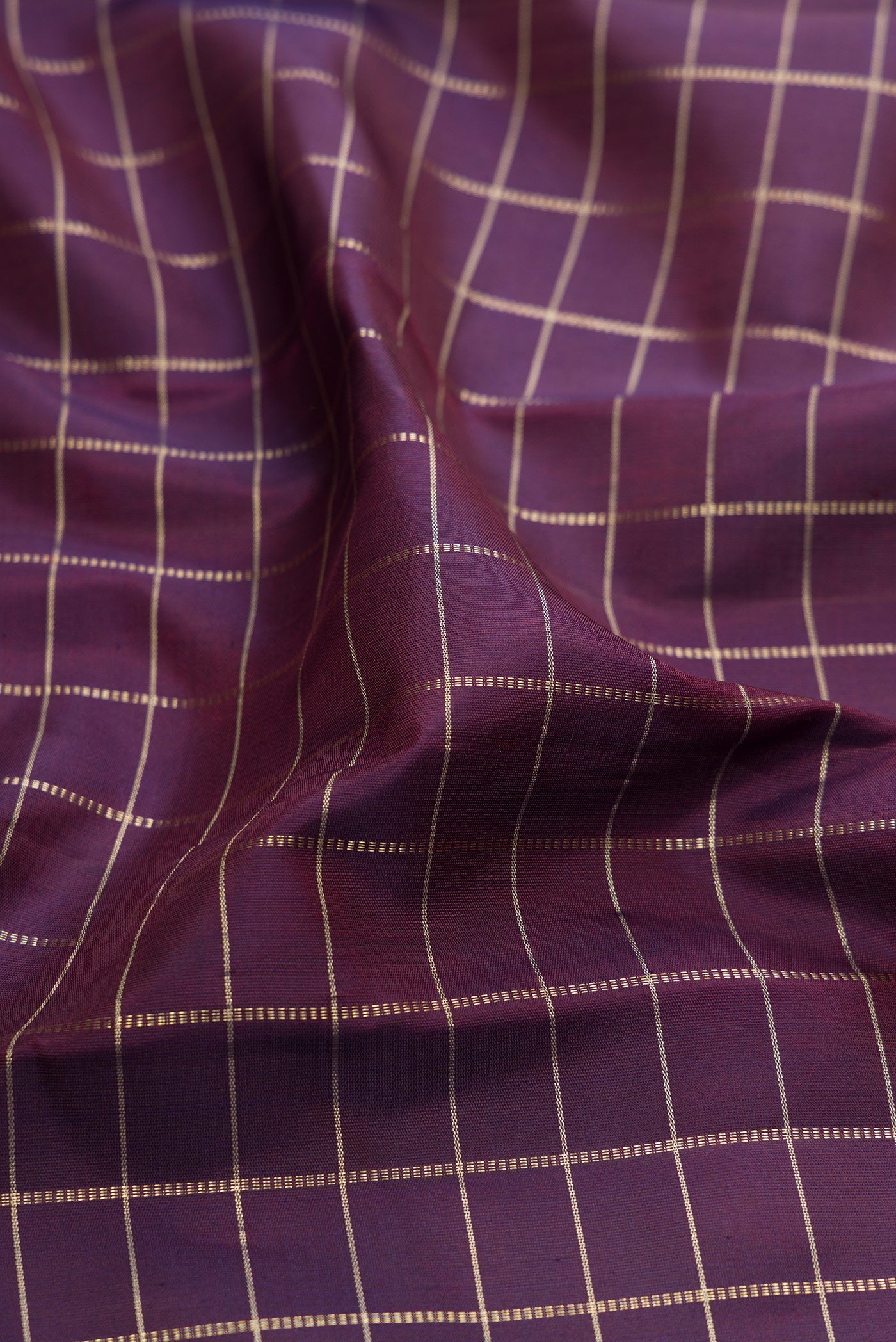 Close up of Purple Kanchipuram Silk Saree with Checked design on the body and Plain Border.  displaying folds