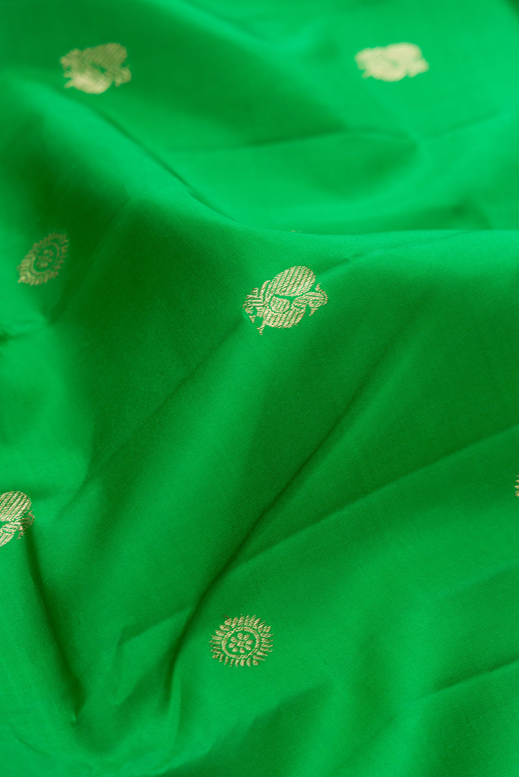 Close up of Green Kanchipuram Silk Saree with Zari Butta on the body and Checks Border.  displaying folds
