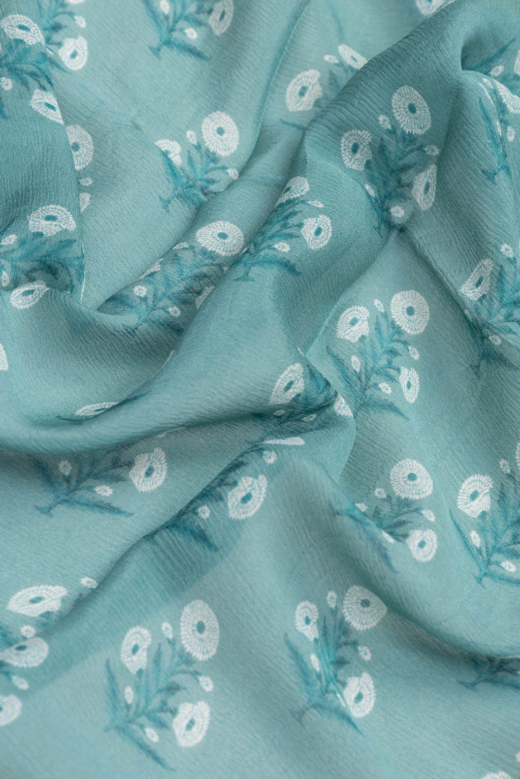 Close up of Maya Blue Dual Tone Mysore Chiffon Saree with Printed design on the body and Zari Border.  displaying folds