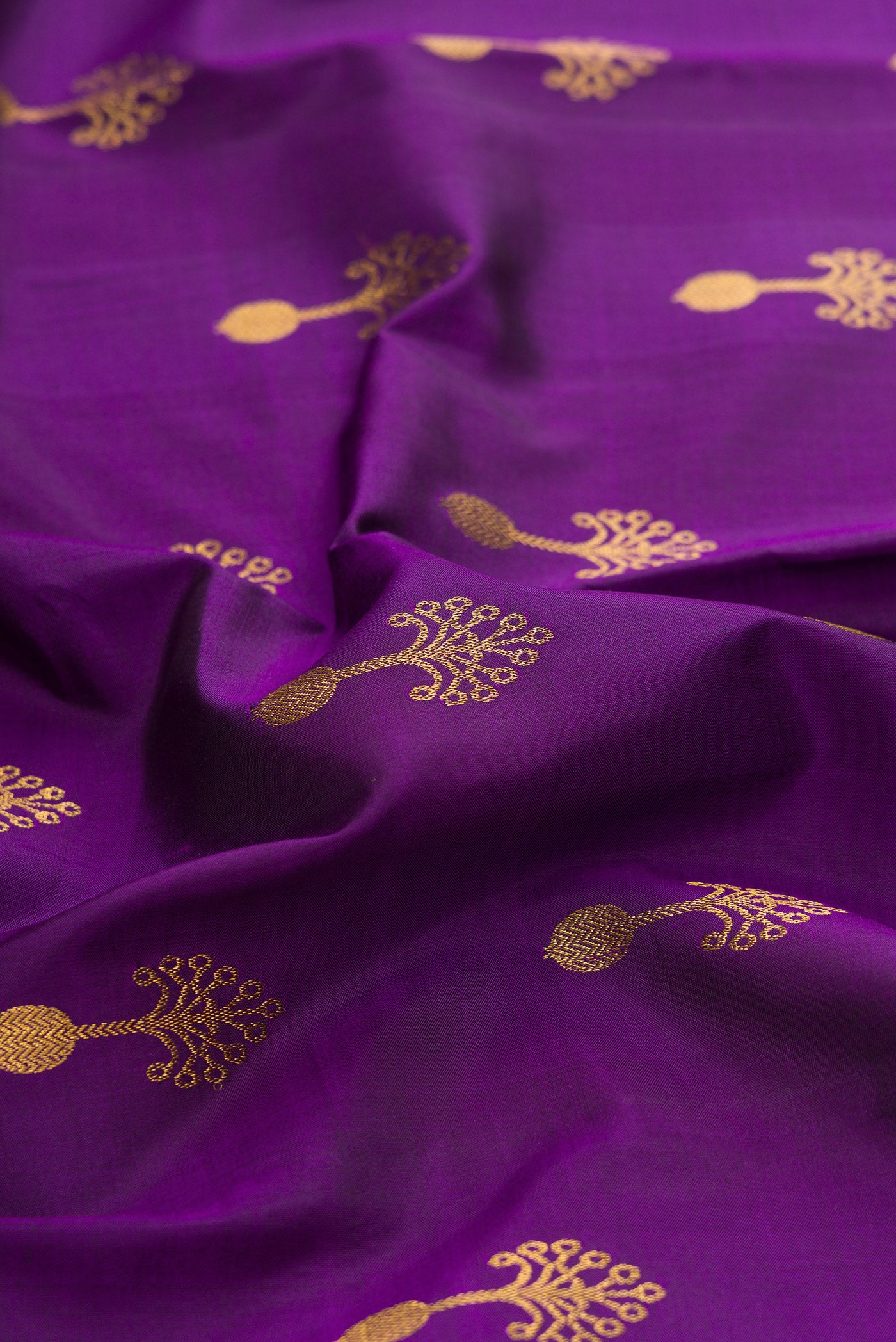 Close up of Purple Kanjivaram Silk Saree with Zari Butta on the body and Zari Border.  displaying folds