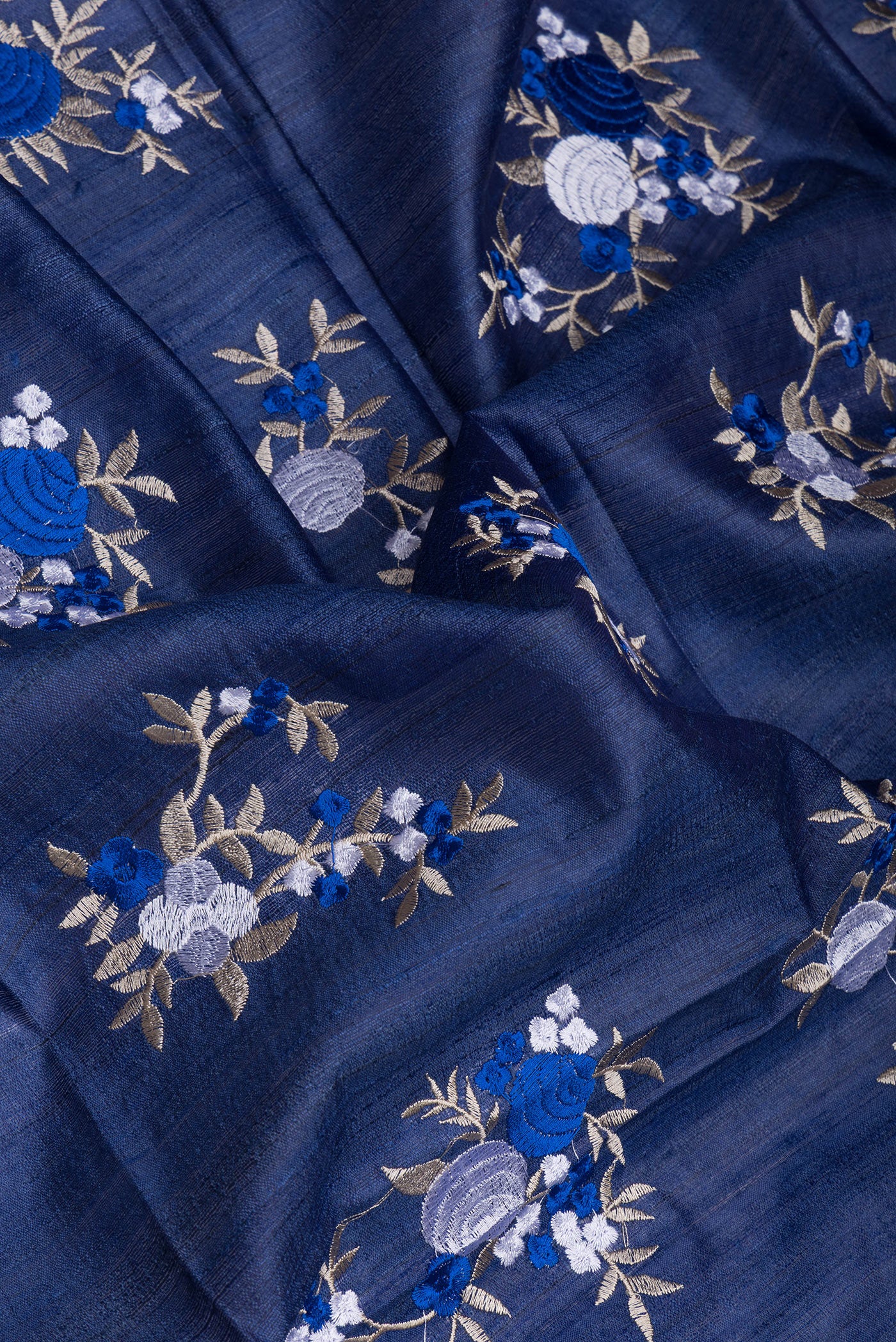 Close up of Dark Blue Tussar Silk Saree with Embroidery on the body and Zari Border.  displaying folds