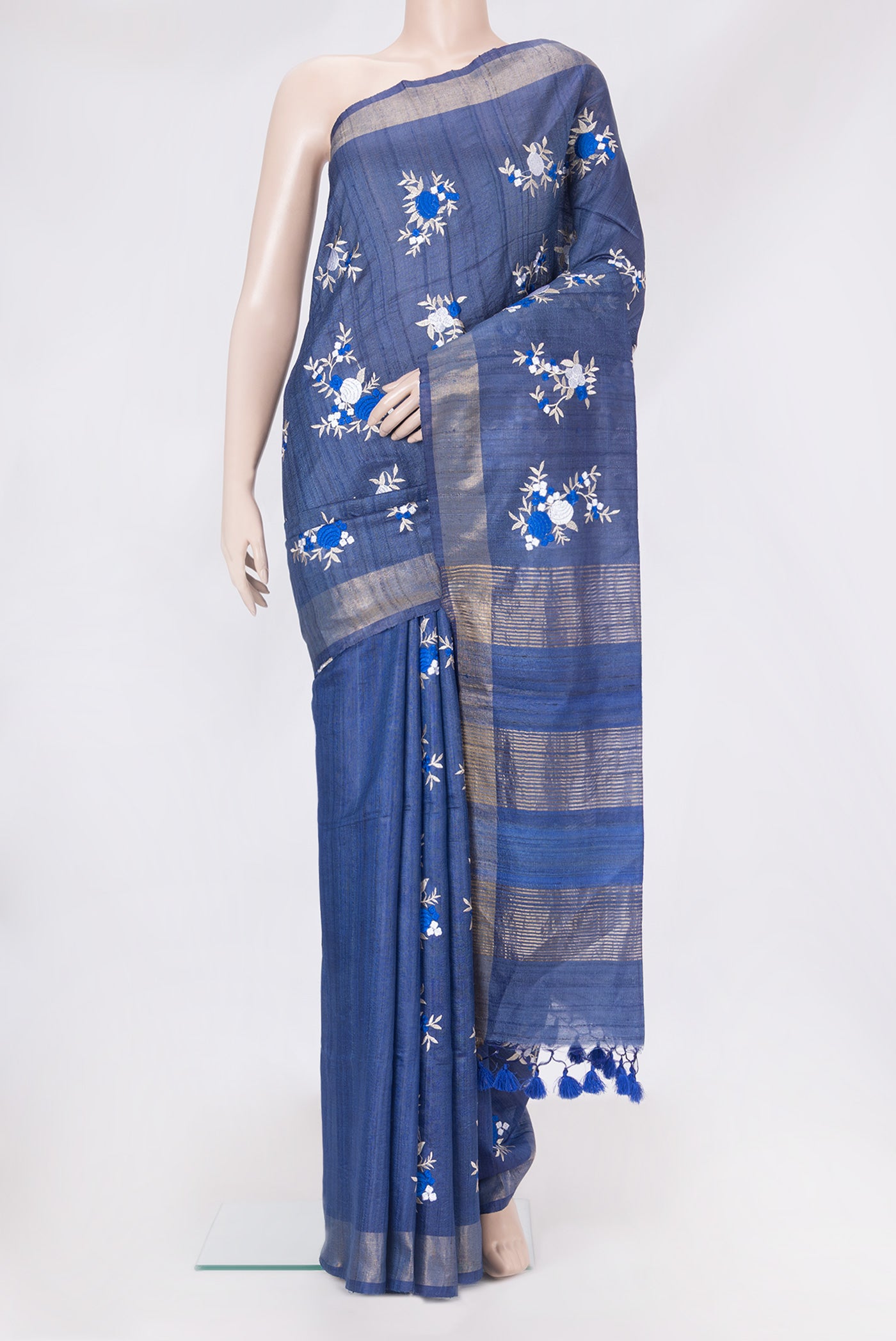 Dark Blue Tussar Silk Saree with Embroidery on the body and Zari Border.  displayed on a mannequin