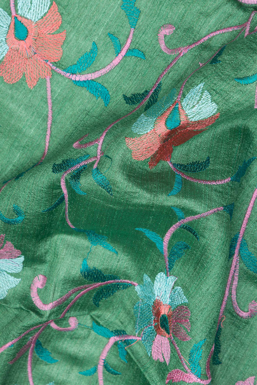 Close up of Green Tussar Saree with Embroidery on the body and Zari Border.  displaying folds