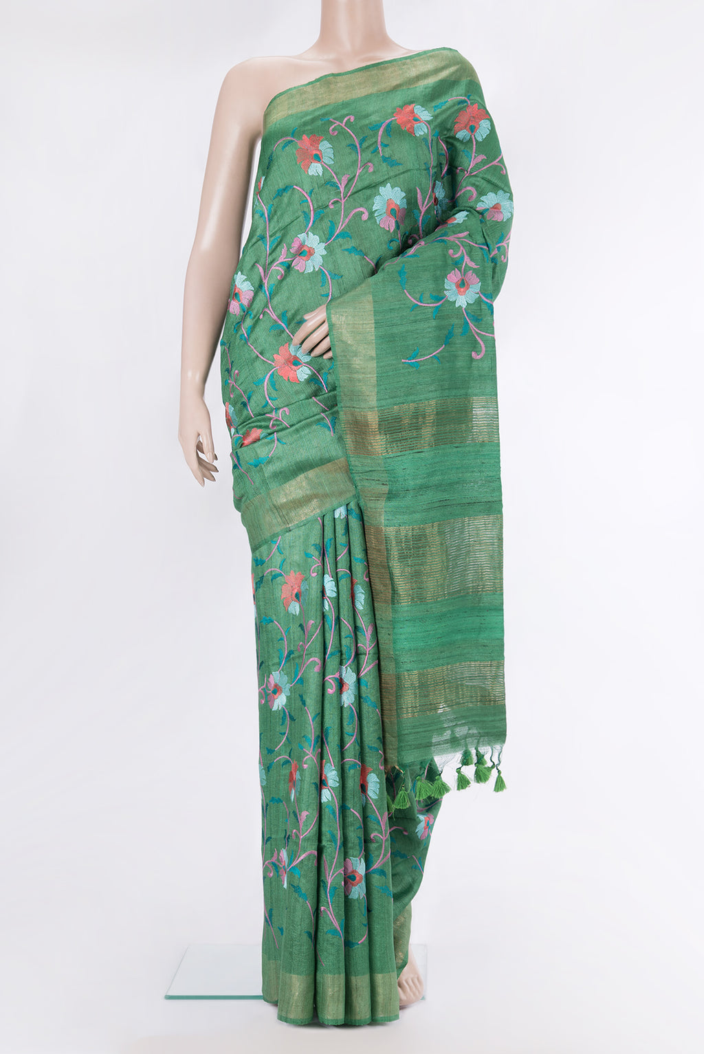Green Tussar Saree with Embroidery on the body and Zari Border.  displayed on a mannequin