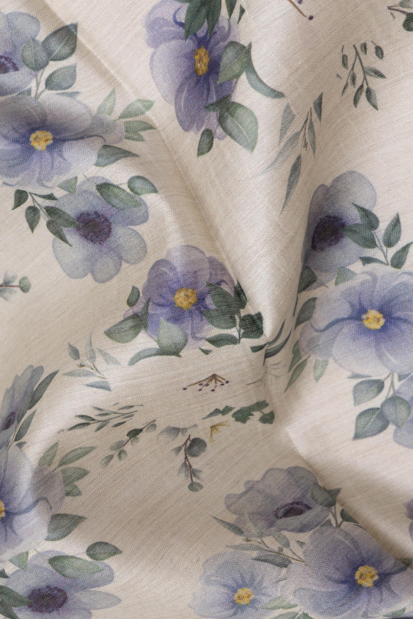 Close up of Beige Tussar Silk Saree with Floral Print on the body and Zari Border.  displaying folds