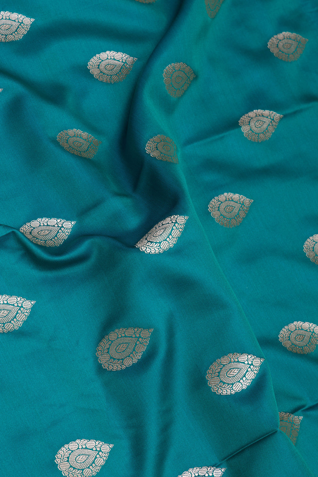 Close up of Peacock Blue Blended Banarasi Silk Saree with Zari Butta on the body and Zari Border.  displaying folds