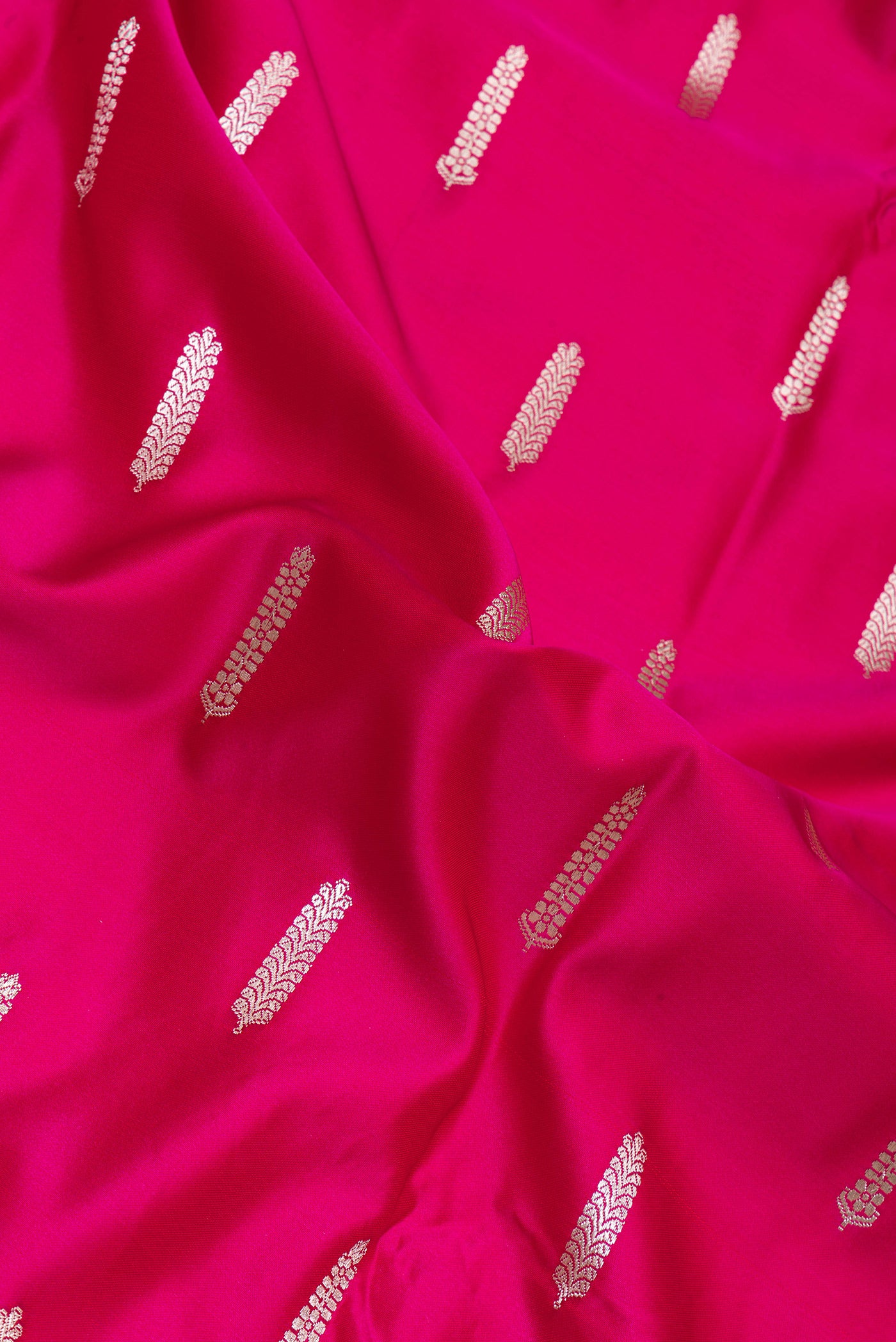 Close up of Dark Pink Blended Banarasi Silk Saree with Zari Butta on the body and Zari Border.  displaying folds