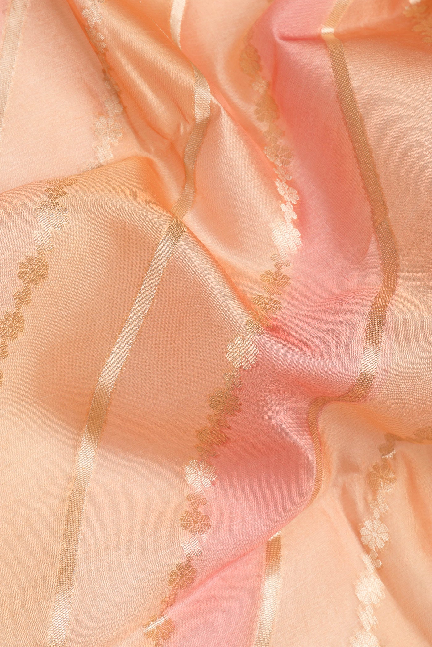 Close up of Golden Peach Tussar Silk Saree with Zari Brocade on the body and Zari Border.  displaying folds
