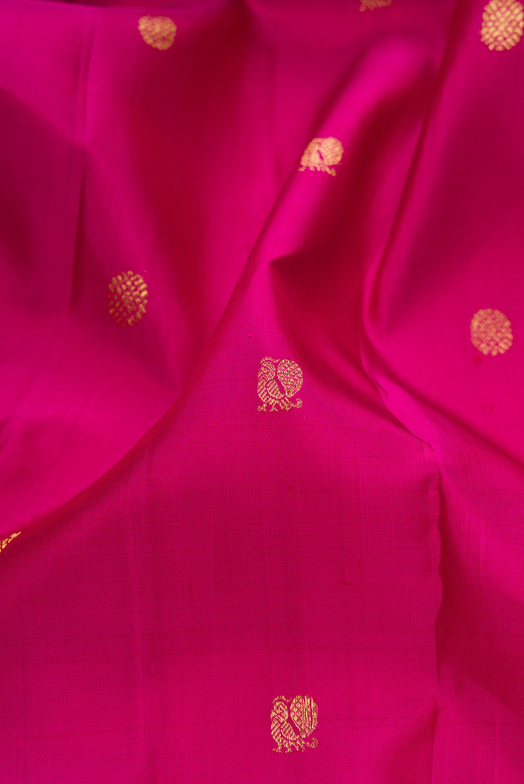 Close up of Pink Kanjivaram Silk Saree with Zari Butta on the body and Zari Border.  displaying folds