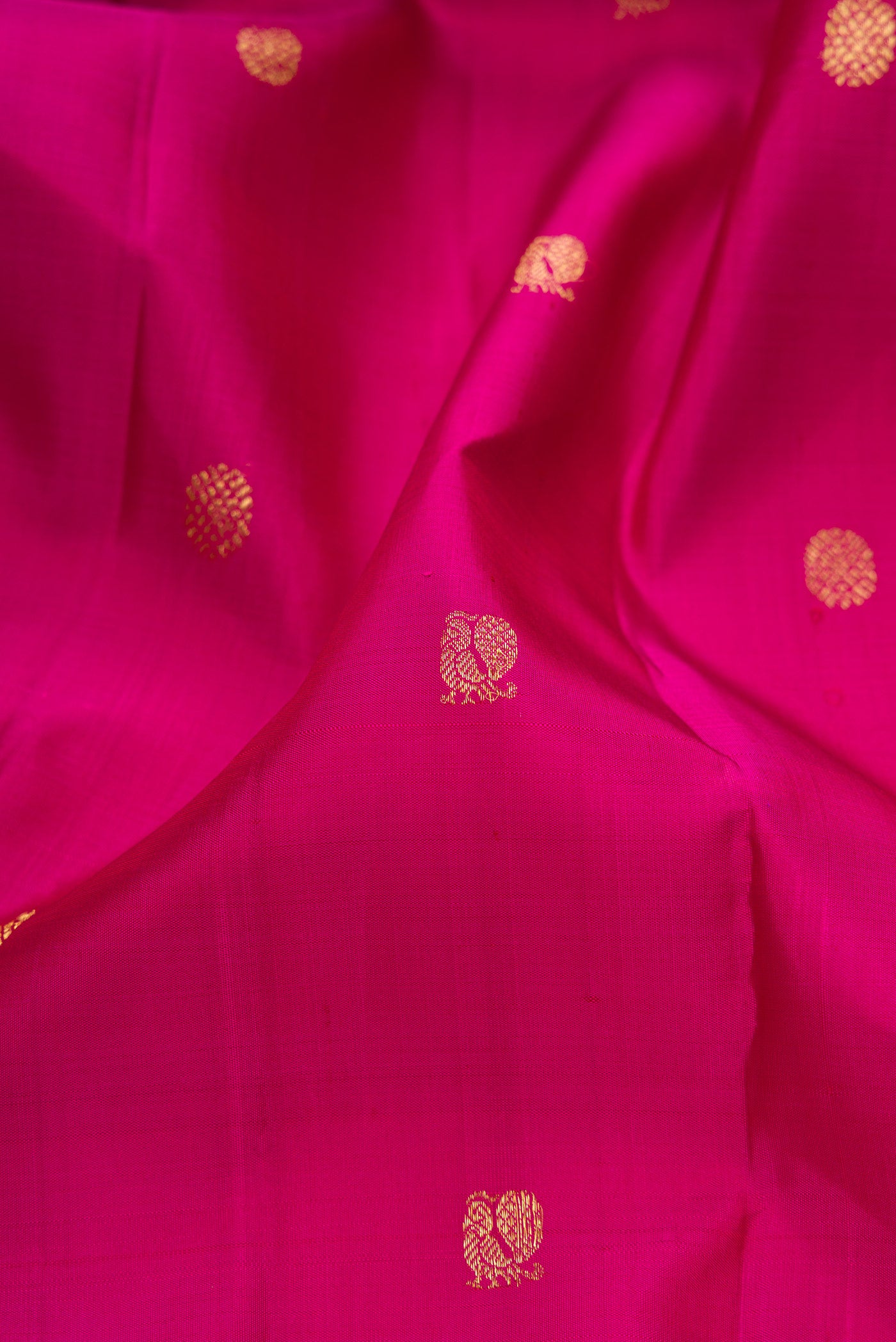 Close up of Pink Kanjivaram Silk Saree with Zari Butta on the body and Zari Border.  displaying folds