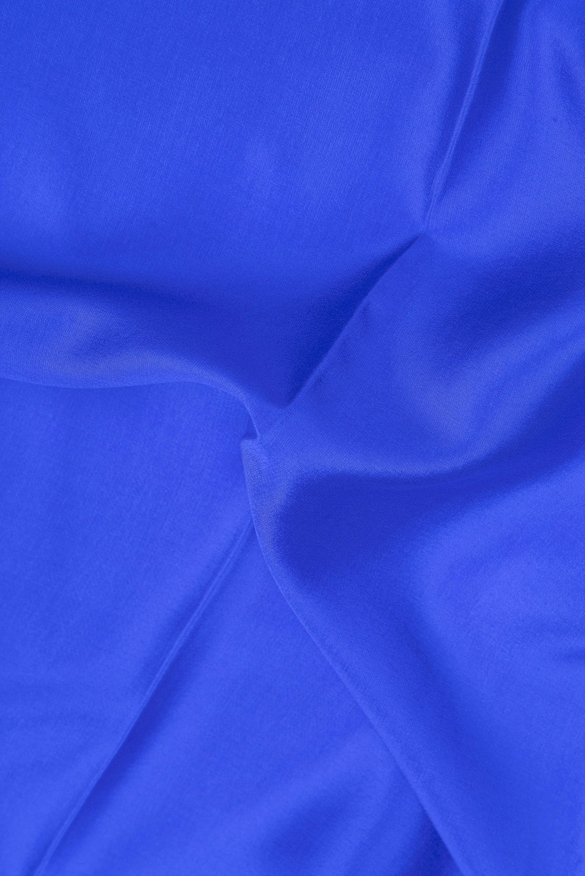 Close up of Royal Blue Mysore Crepe Saree with Plain Body and Zari Border.  displaying folds