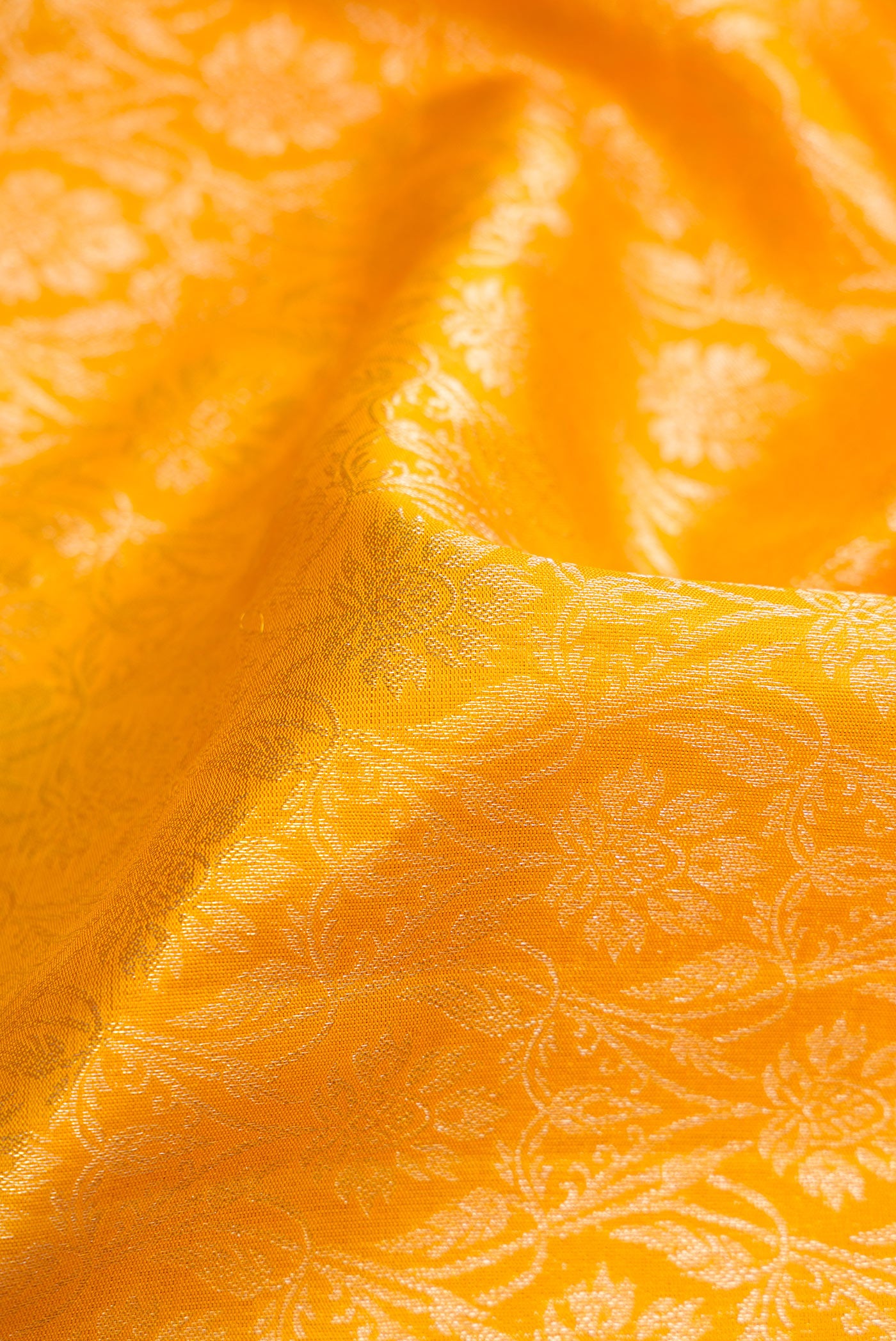 Close up of Mustard Dual Tone Kanchipuram Silk Saree with Zari Brocade on the body and Zari Border.  displaying folds