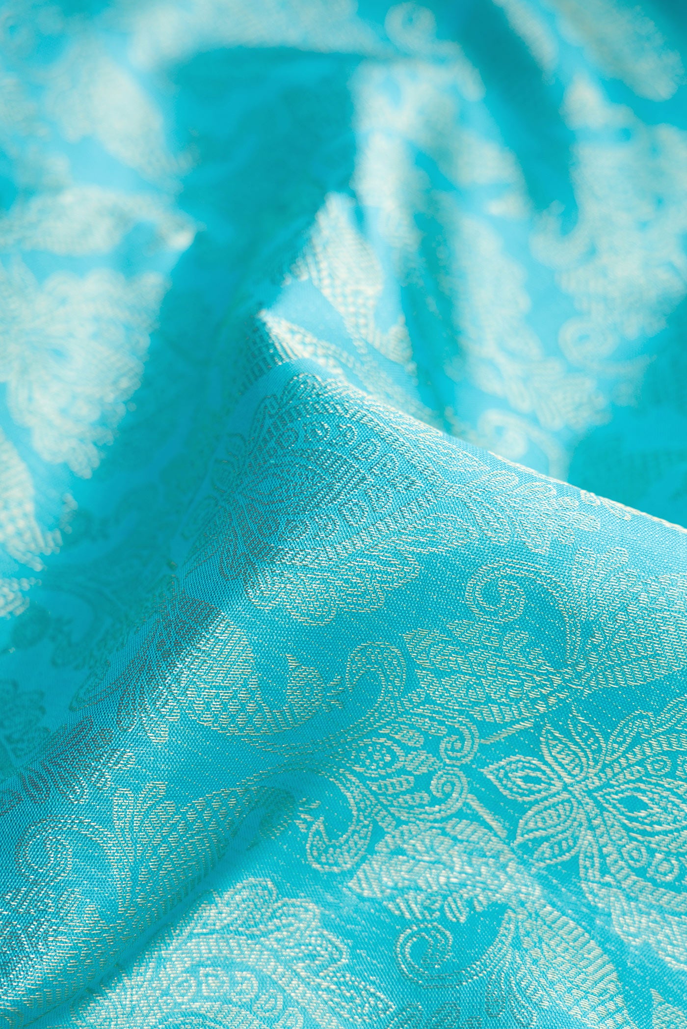 Close up of Sky Blue Dual Tone Kanchipuram Silk Saree with Zari Brocade on the body and Fancy Border.  displaying folds