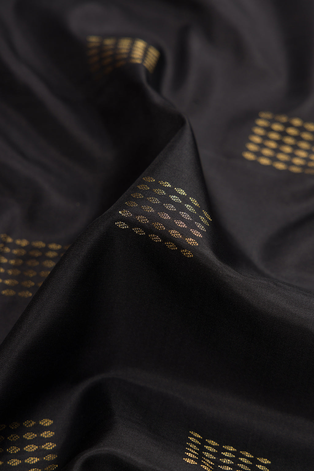 Close up of Black Dual Tone Soft Silk Saree with Zari Butta on the body and Zari Border.  displaying folds
