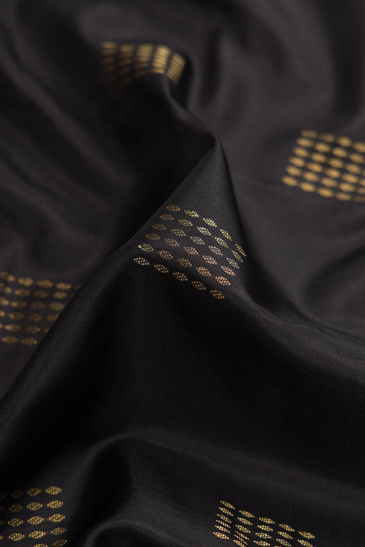 Close up of Black Dual Tone Soft Silk Saree with Zari Butta on the body and Zari Border.  displaying folds