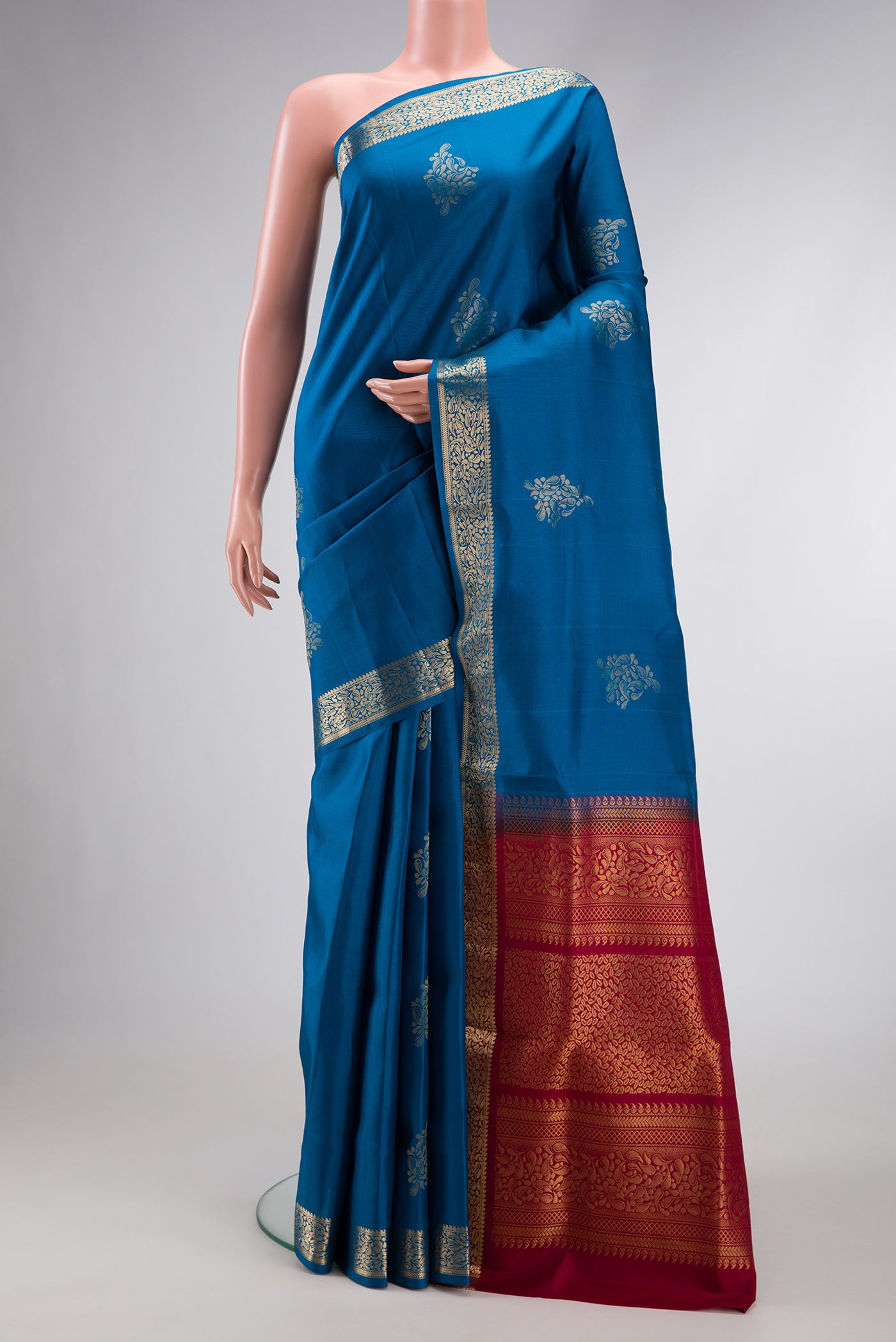 Peacock Blue Dual Tone Soft Silk Saree with Zari Butta on the body and Zari Border.  displayed on a mannequin