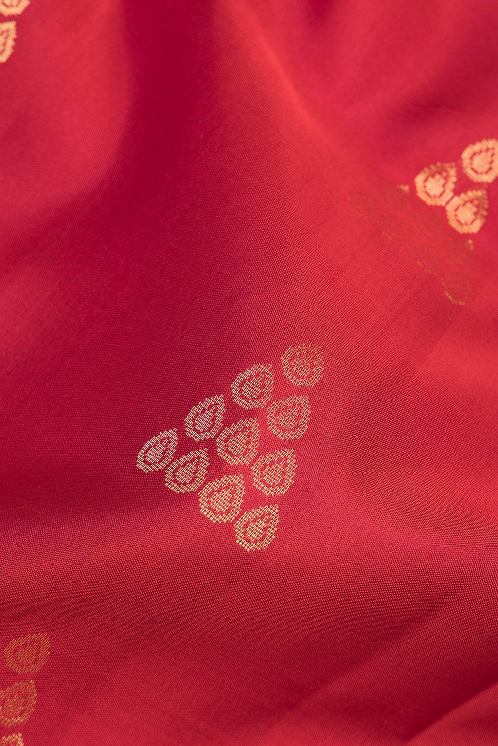 Close up of Pure Silk Red Soft Saree with Zari Butta on the body and Zari Border.  displaying folds