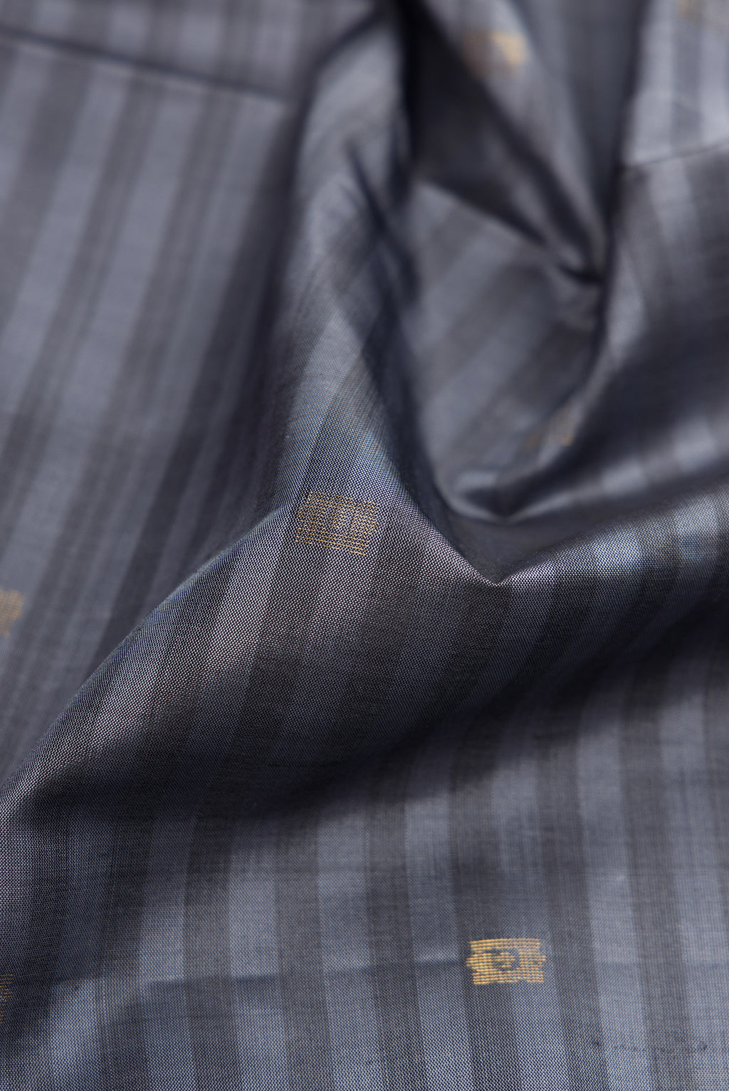 Close up of Grey Dual Tone Soft Silk Saree with Stripes on the body and Fancy Border.  displaying folds
