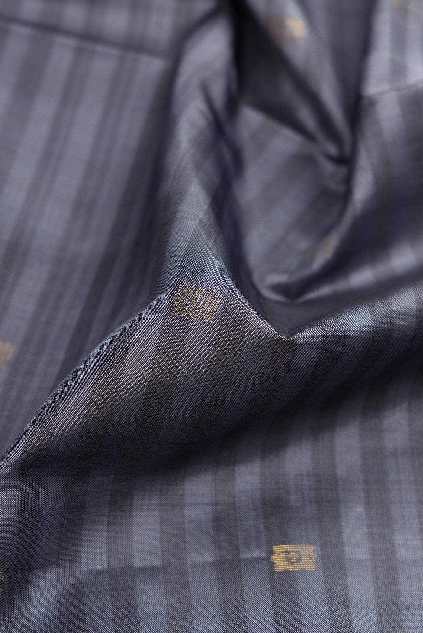Close up of Grey Dual Tone Soft Silk Saree with Stripes on the body and Fancy Border.  displaying folds