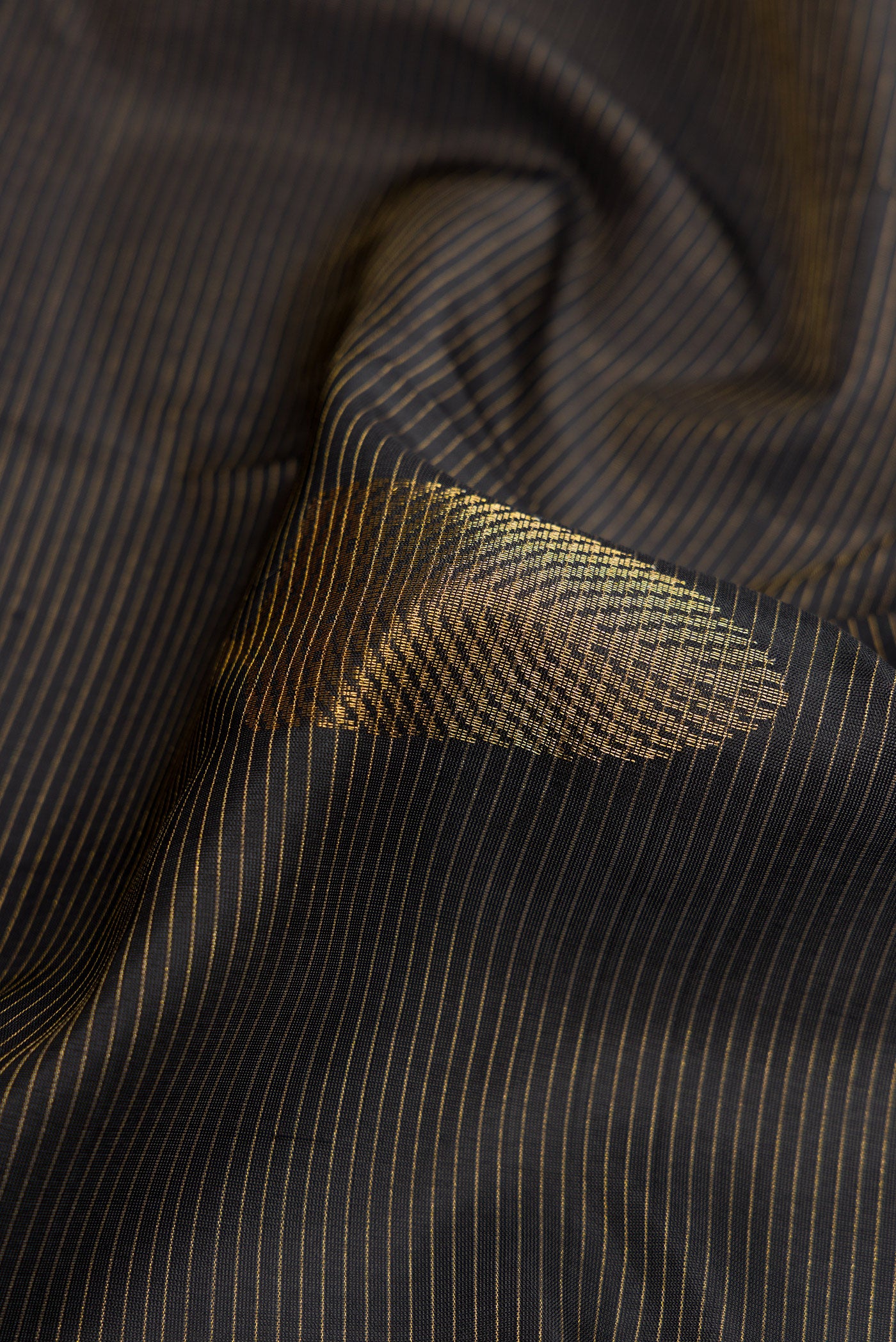 Close up of Black Dual Tone Soft Silk Saree with Stripes on the body and Plain Border.  displaying folds