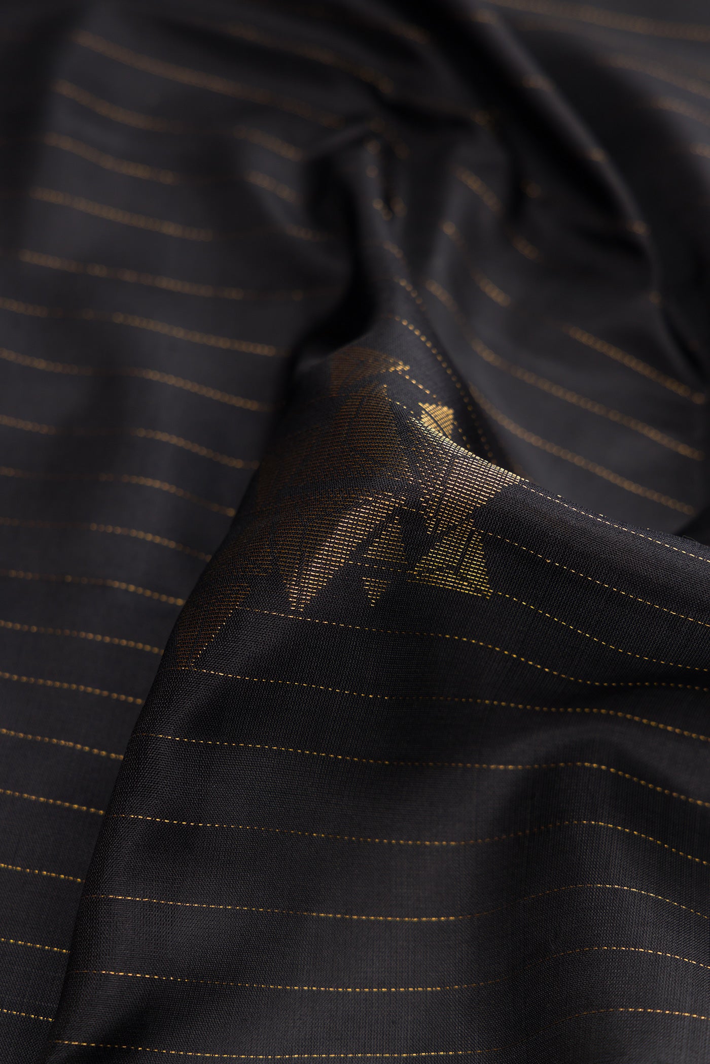 Close up of Black Dual Tone Soft Silk Saree with Stripes on the body and Zari Border.  displaying folds