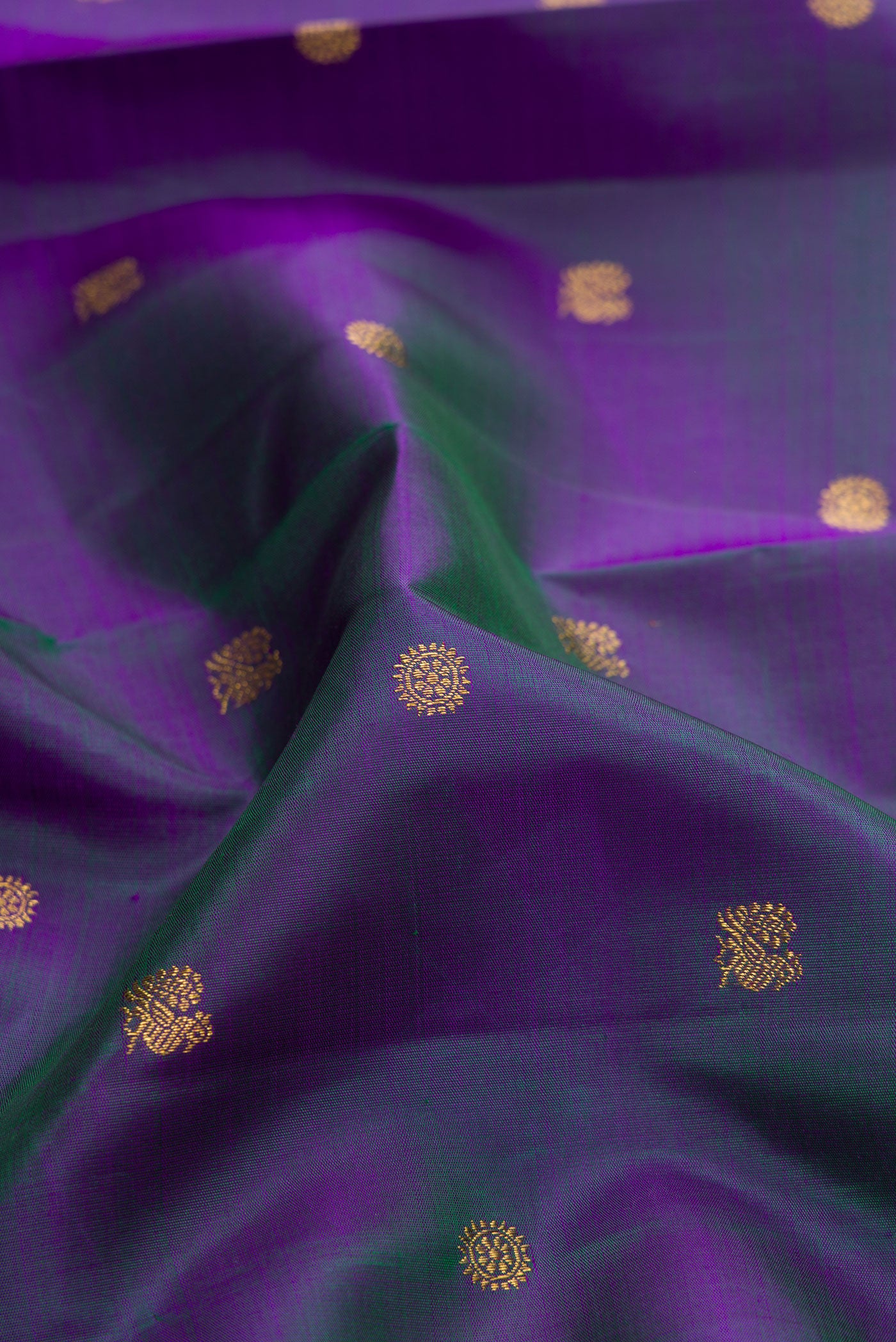 Close up of Peacock Blue Dual Tone Kanchipuram Silk Saree with Zari Butta on the body and Zari Border.  displaying folds