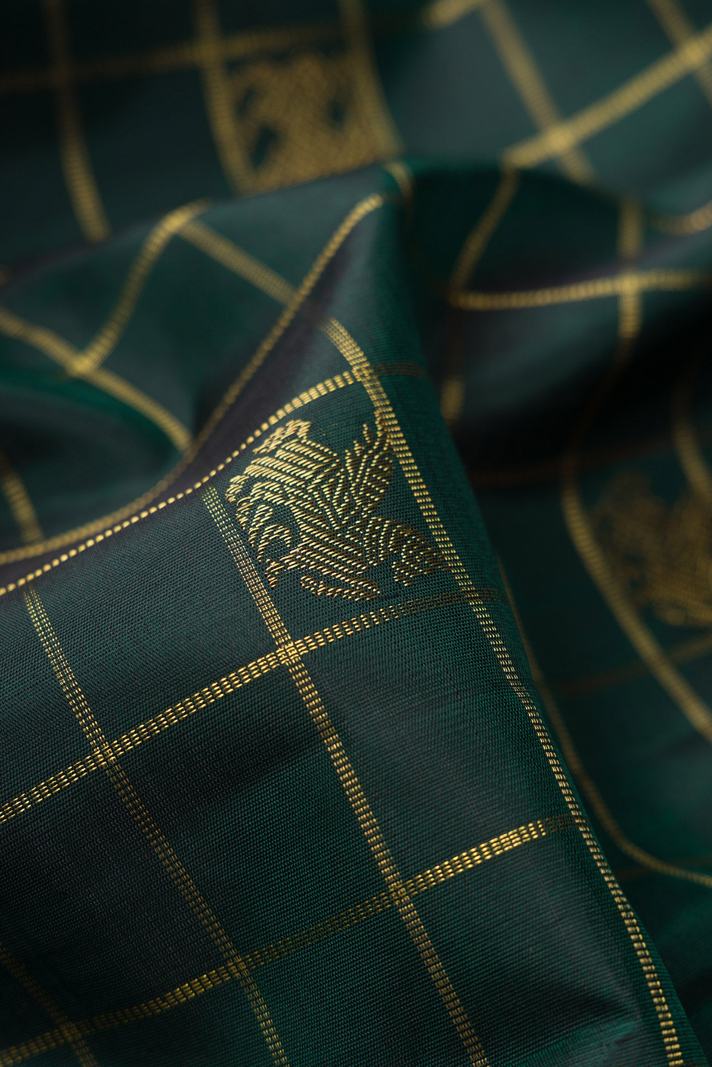 Close up of Pure Silk Pure Zari Bottle Green Dual Tone Kanjivaram Saree with Checked design on the body and Thin Zari Line.  displaying folds