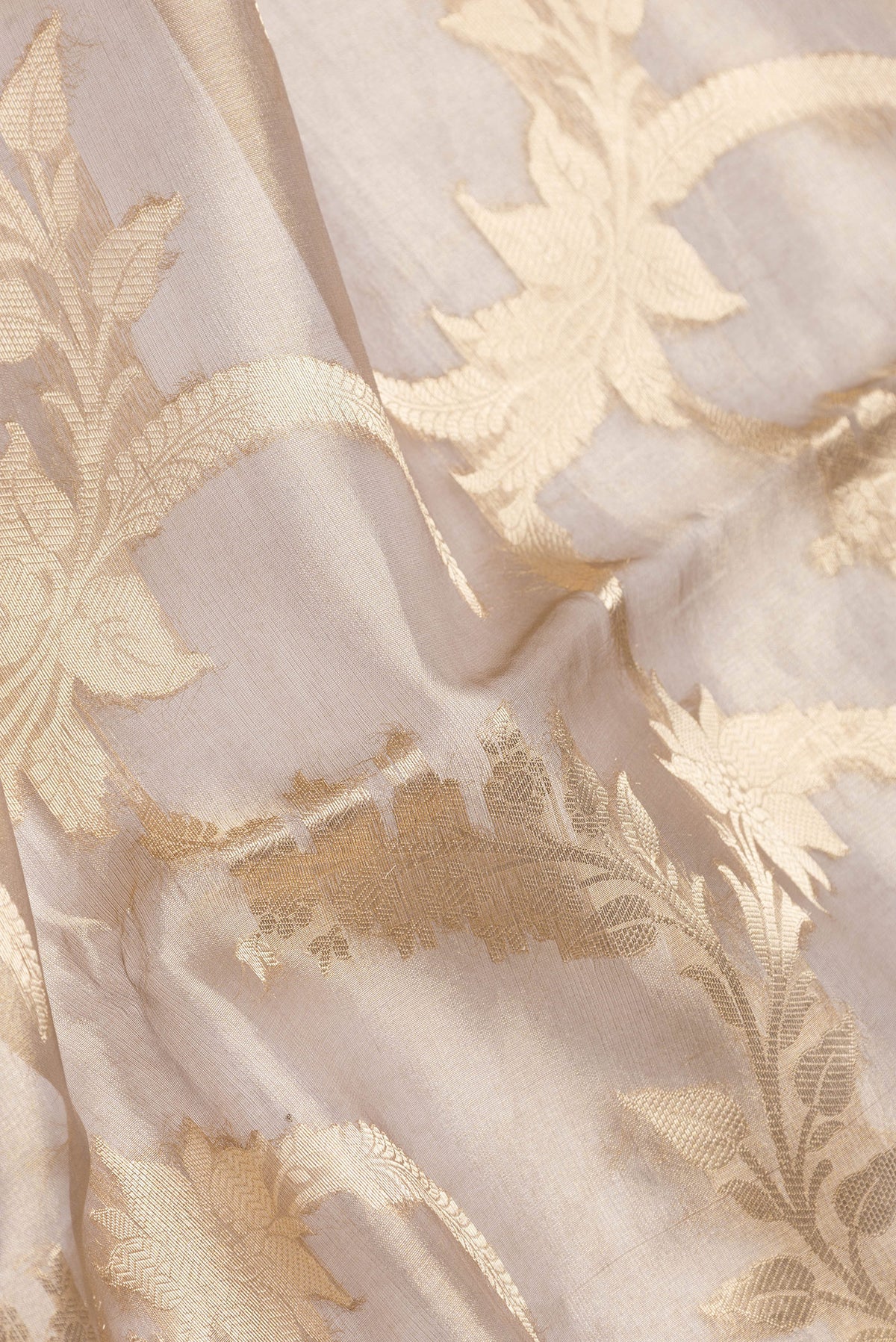 Close up of Gold Dual Tone Organza Silk Saree with Zari Brocade on the body and Zari Border.  displaying folds