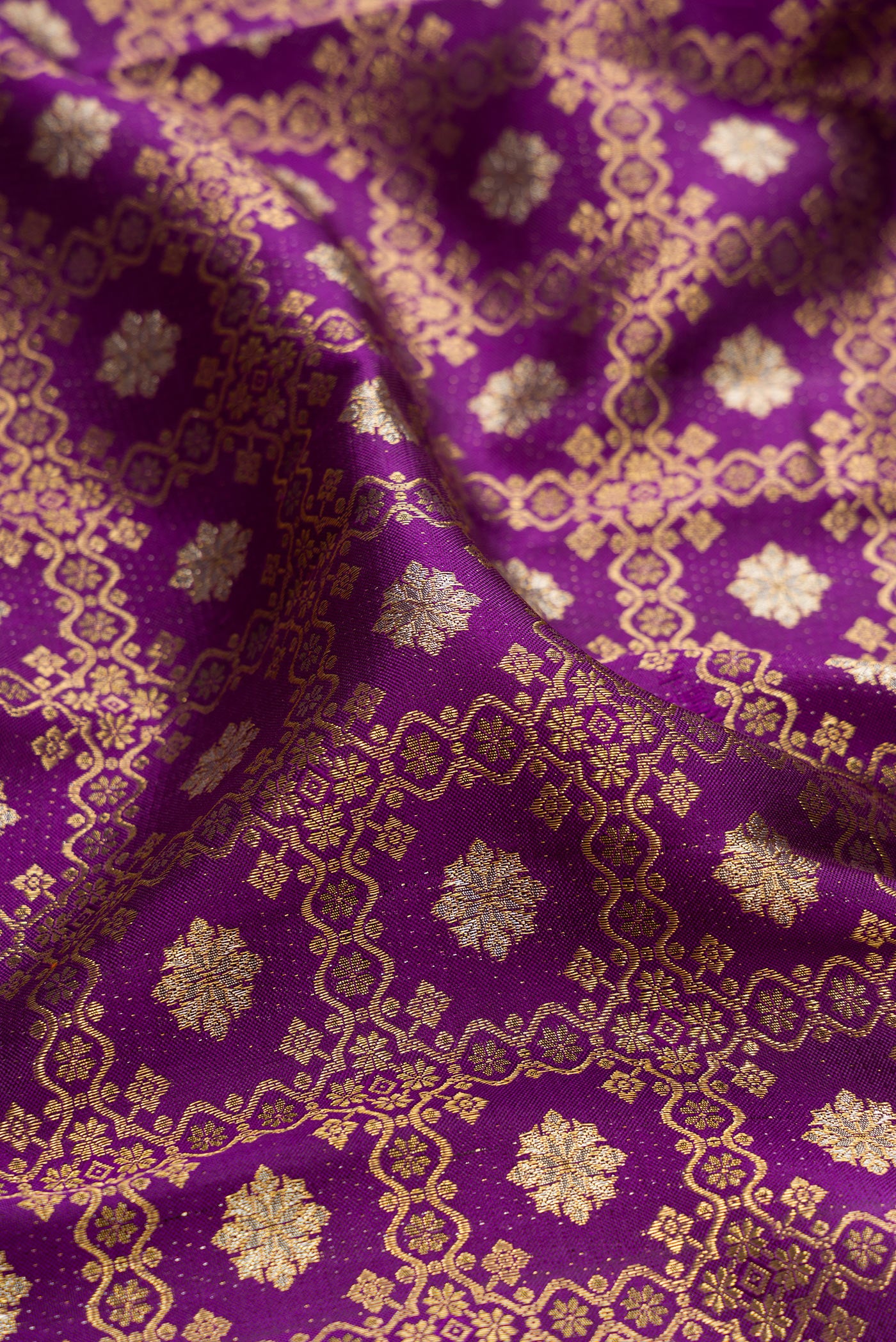 Close up of Purple Kanchipuram Silk Saree with Zari Brocade on the body and Zari Border.  displaying folds